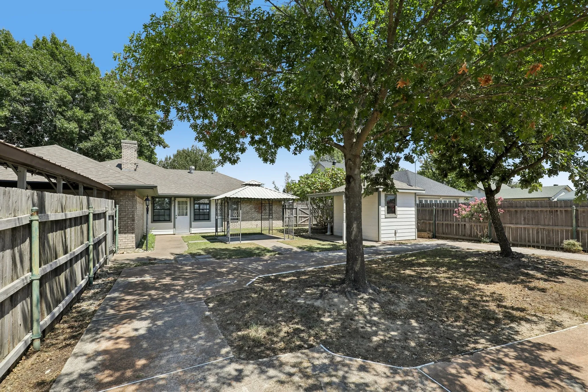 Spacious back yard with mature shade trees and workshop