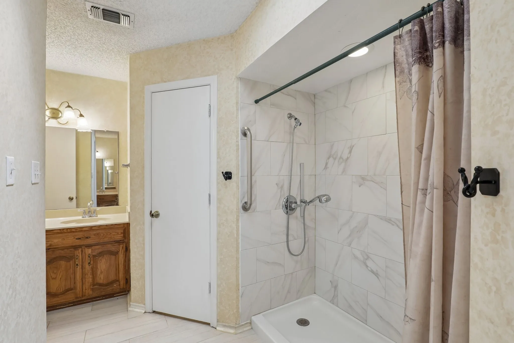 White tile flooring with large walk-in shower