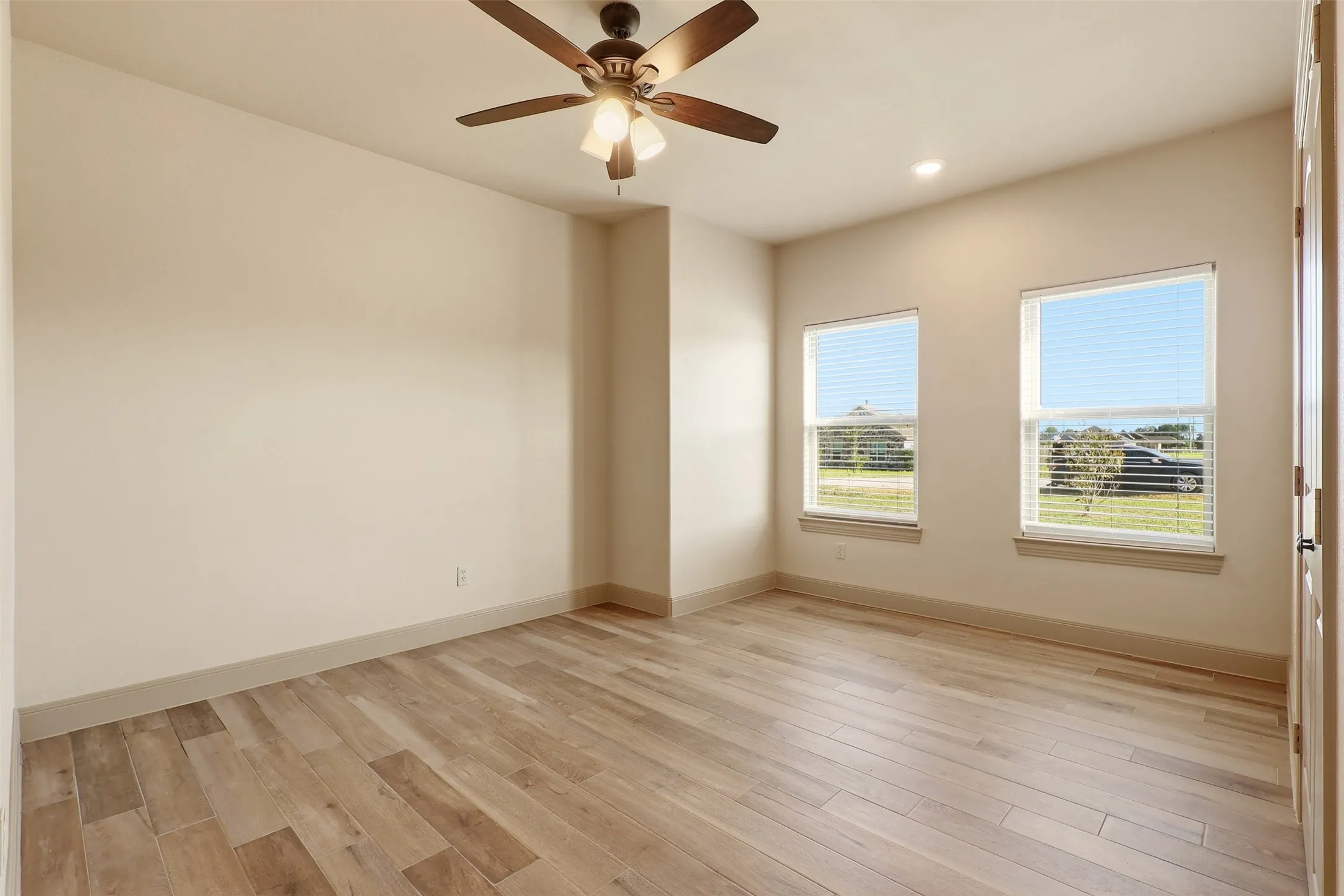 Wood-finish flooring, recessed lighting, and a ceiling fan with light fixture