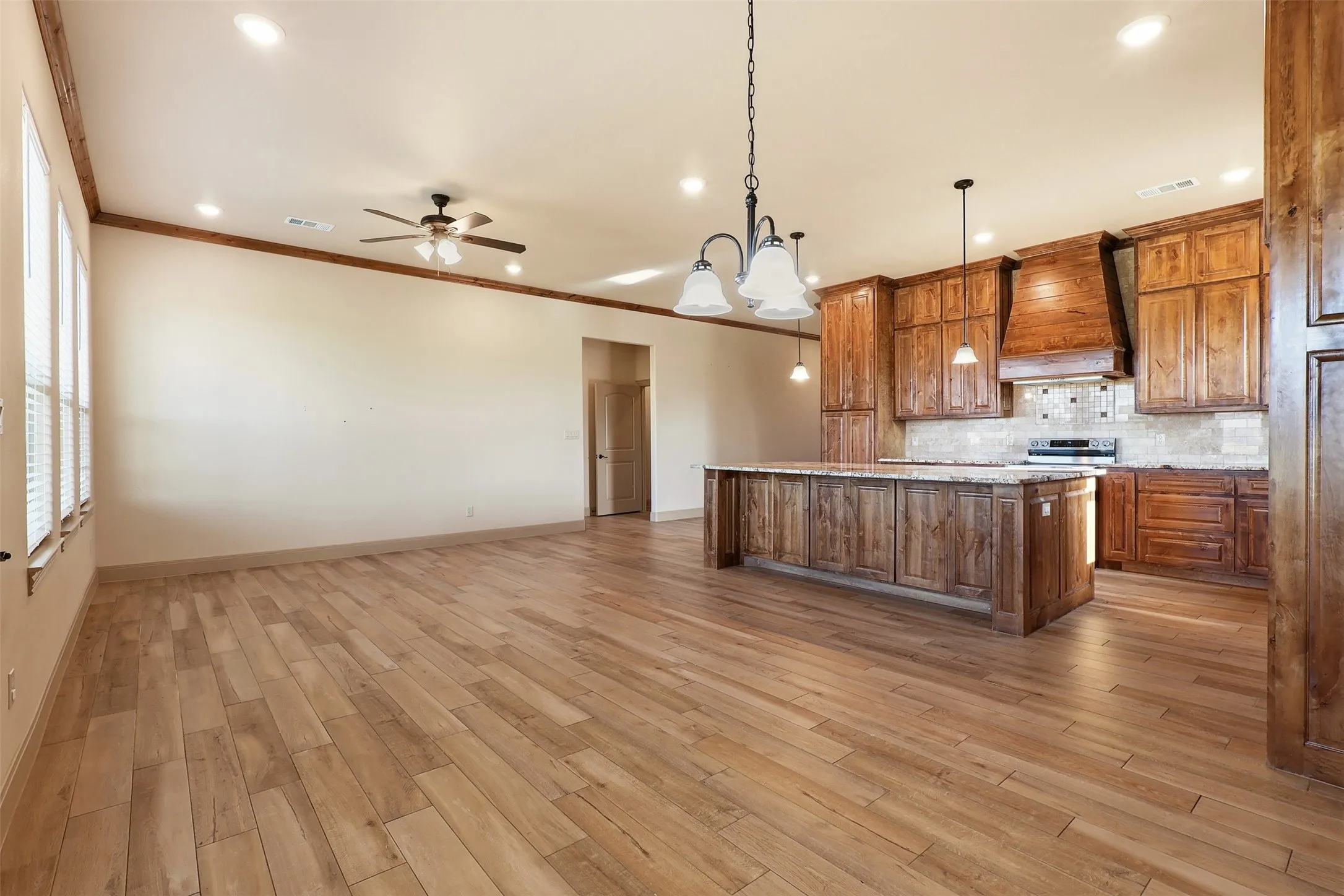 Open-concept design featuring wood-finish flooring, recessed lighting, and a ceiling fan