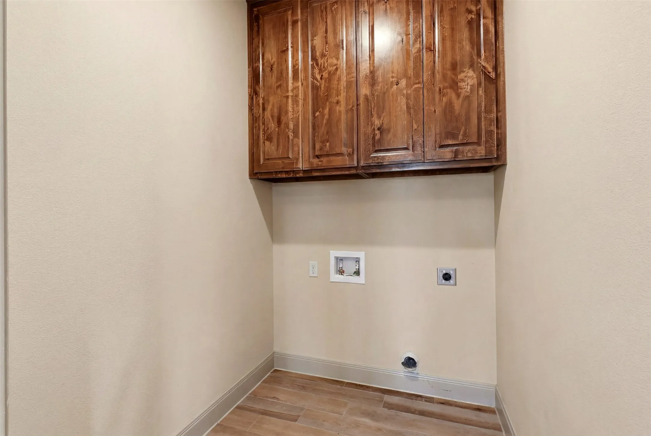 Wood-finish flooring, light-toned walls, and wood-toned cabinetry