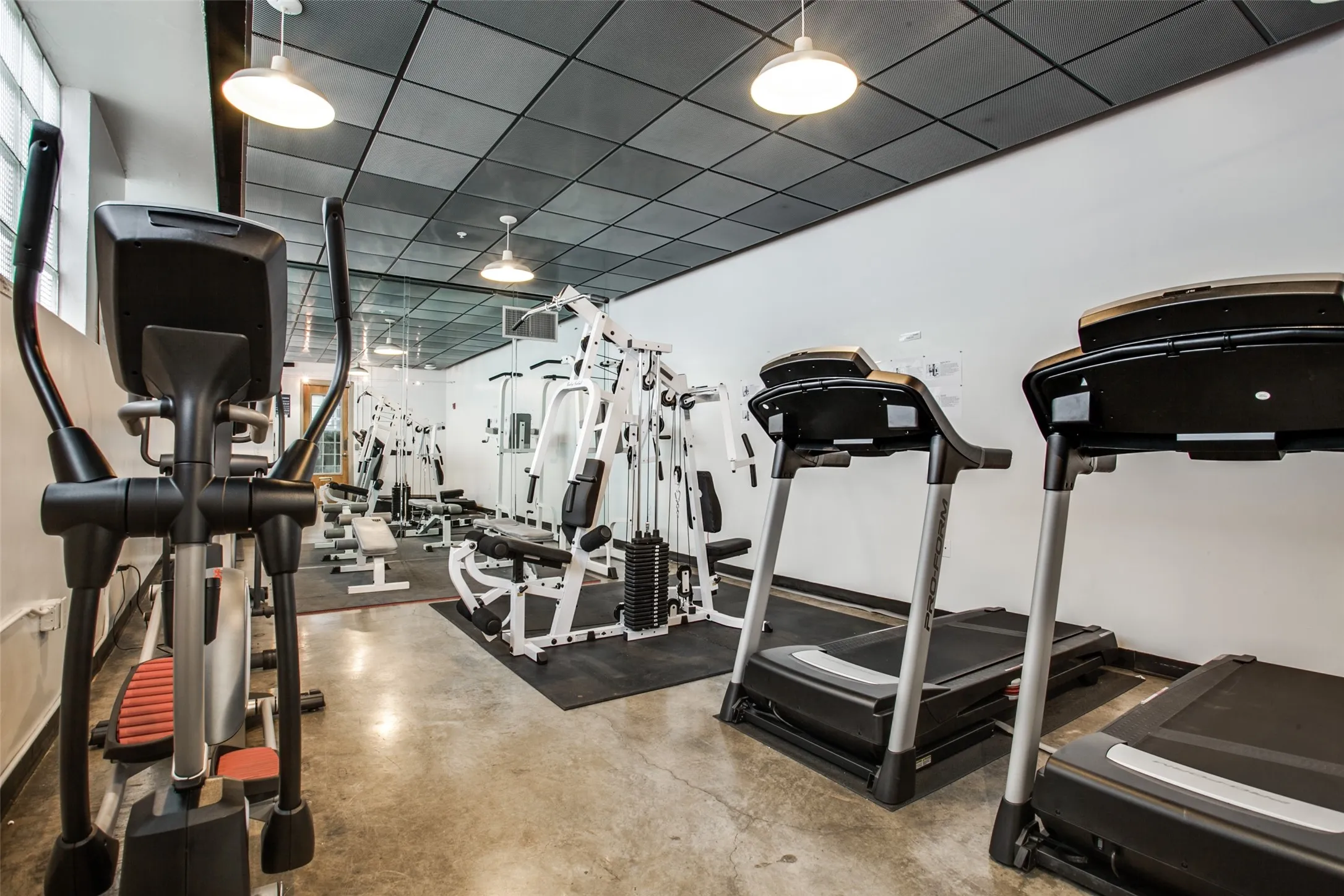 State-of-the-art fitness facility featuring multiple treadmills with digital displays, elliptical cardio equipment, and strength training machines