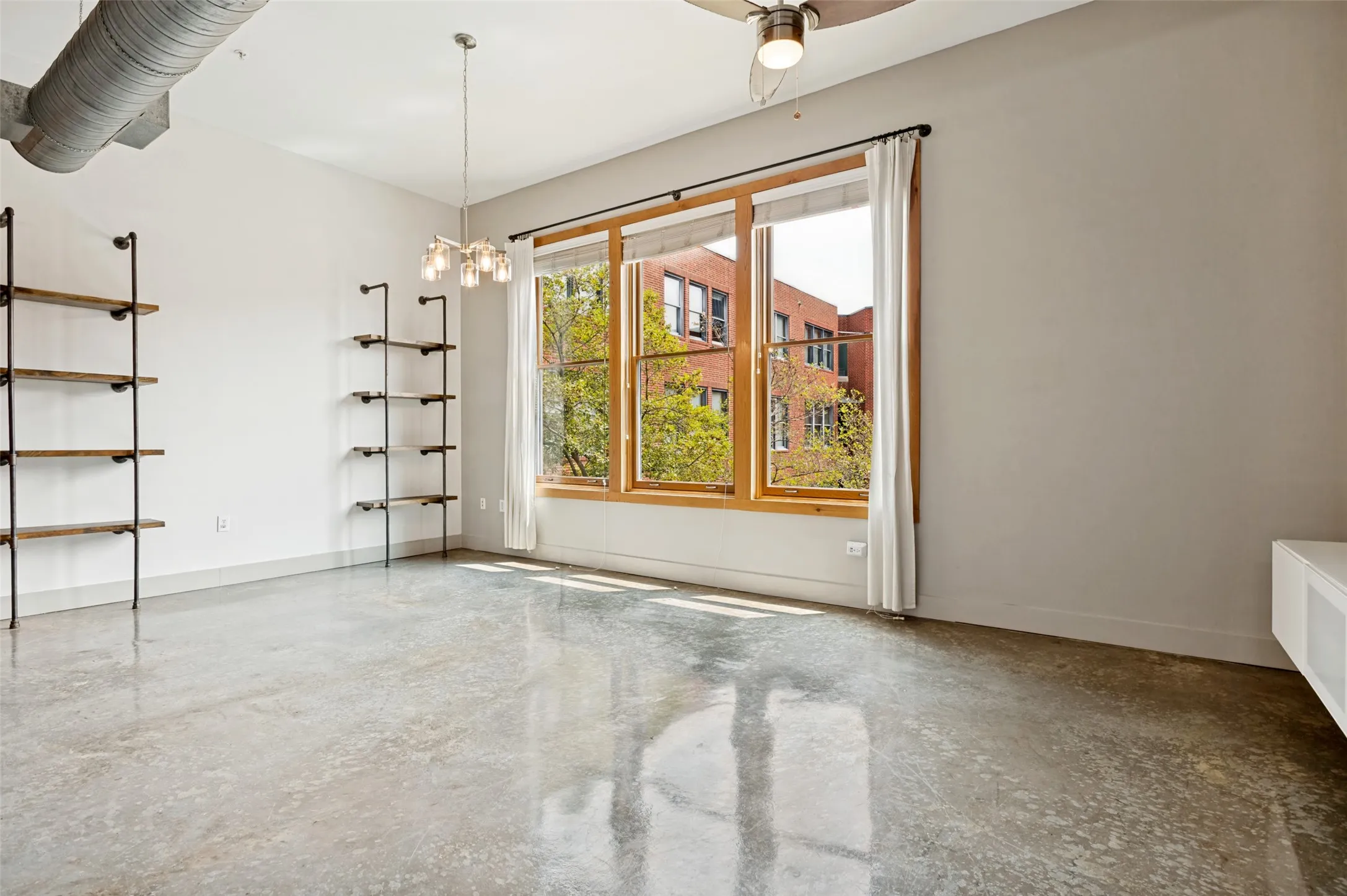 The main living area includes two built-in shelving units that complement the windows, wood trim, and exposed ductwork