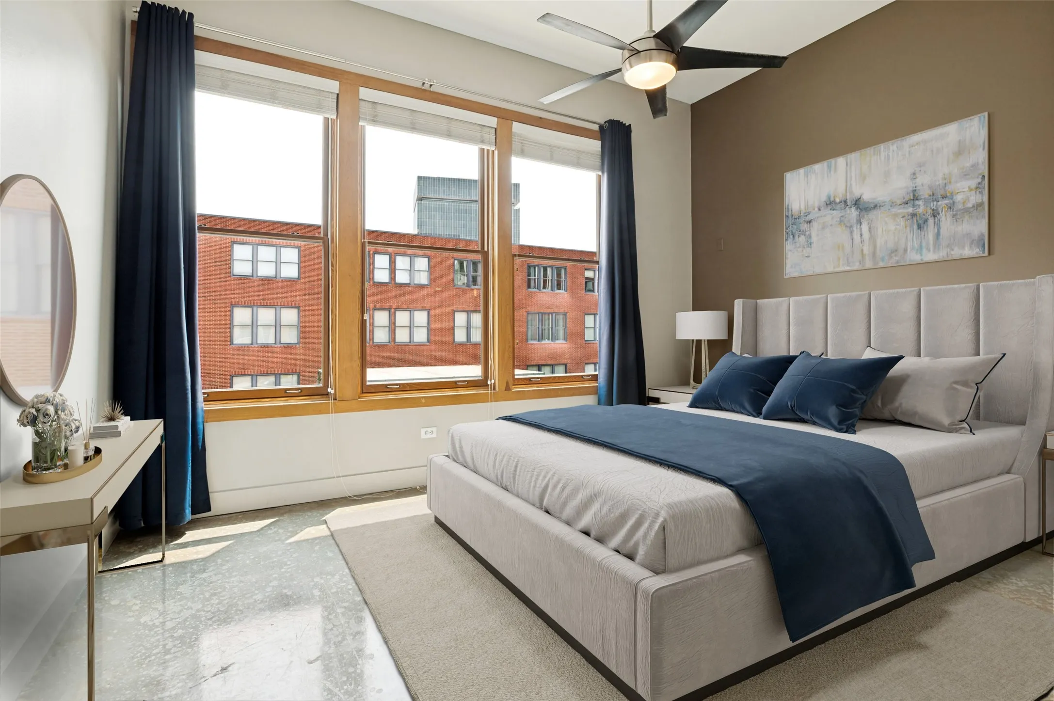 Expansive windows with wood trim, ceiling fan, accent wall, and polished concrete flooring