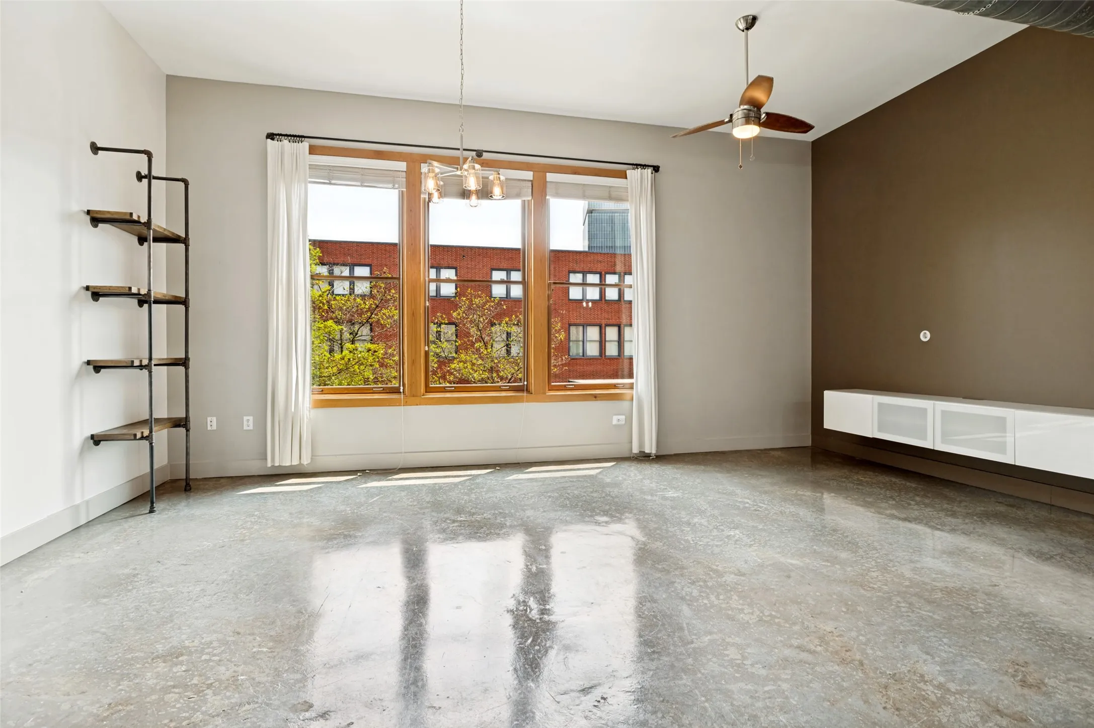 Living area with polished concrete flooring, built-ins, and huge windows