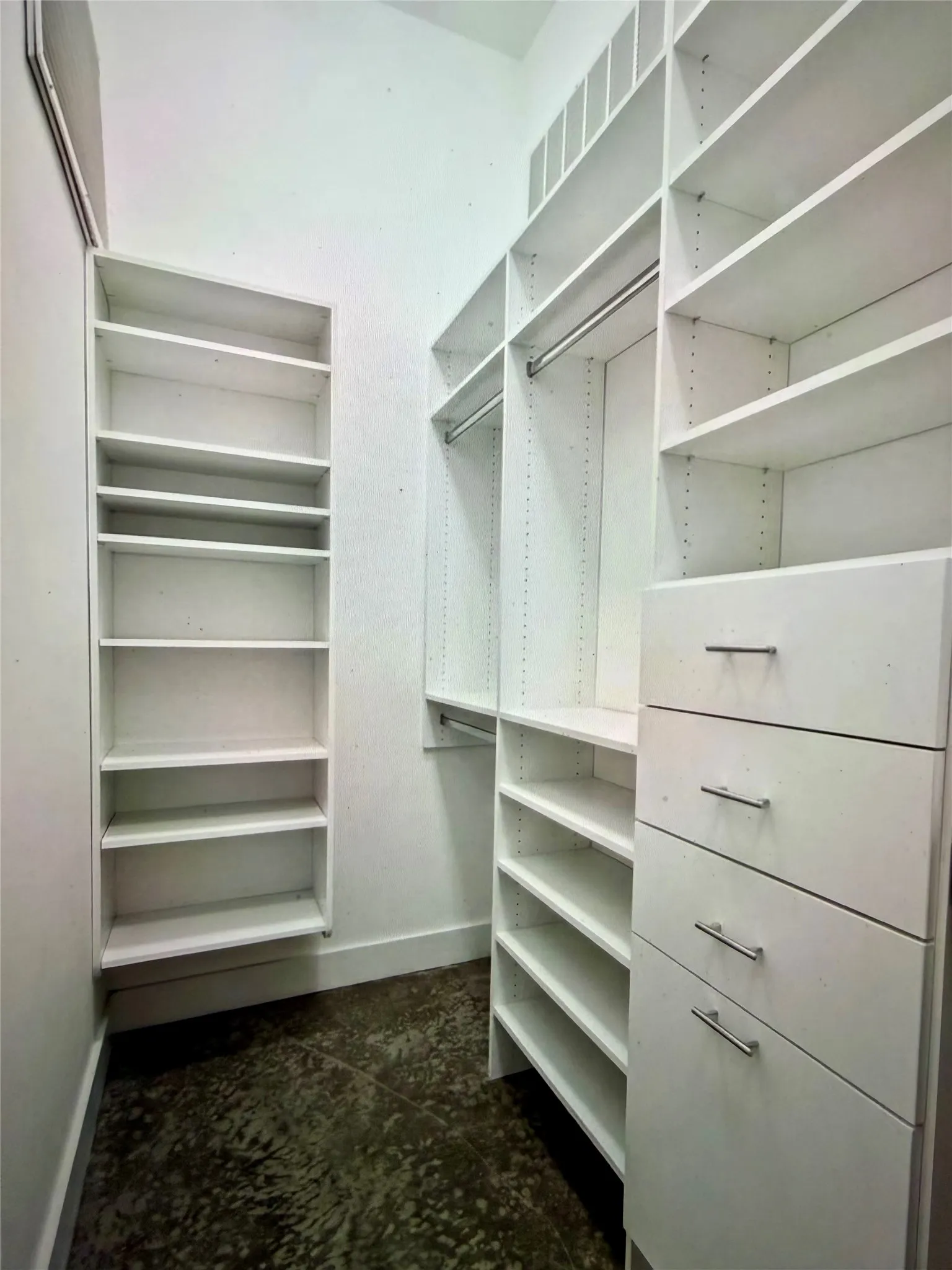 Integrated custom closet system with varied shelving, hanging rods, and built-in drawers