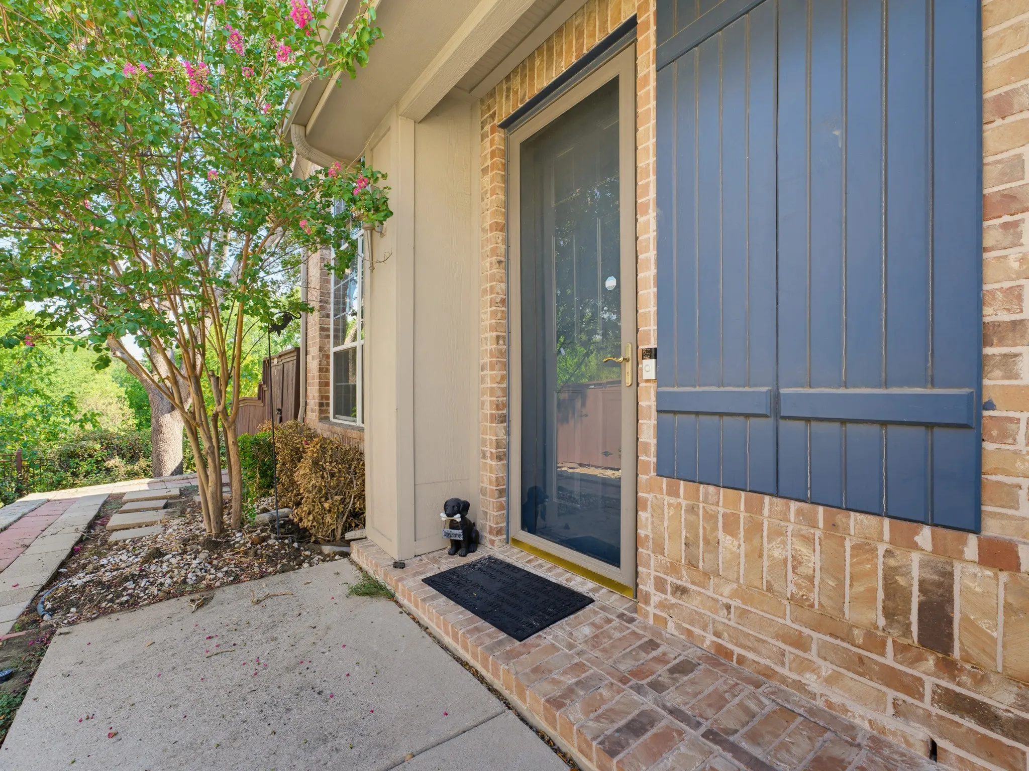 Brick exterior with blue shutters, a screen door, and a concrete​​‌​​​​‌​​‌‌​‌‌​​​‌‌​‌​‌​‌​​​‌​​ walkway