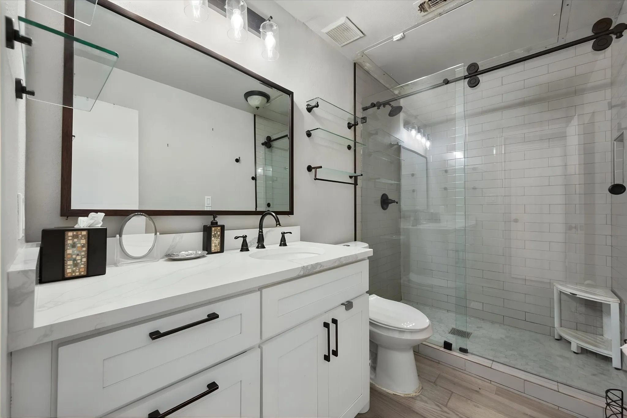 Beautifully updated bath. Vanity with a quartz countertop, and walk in shower