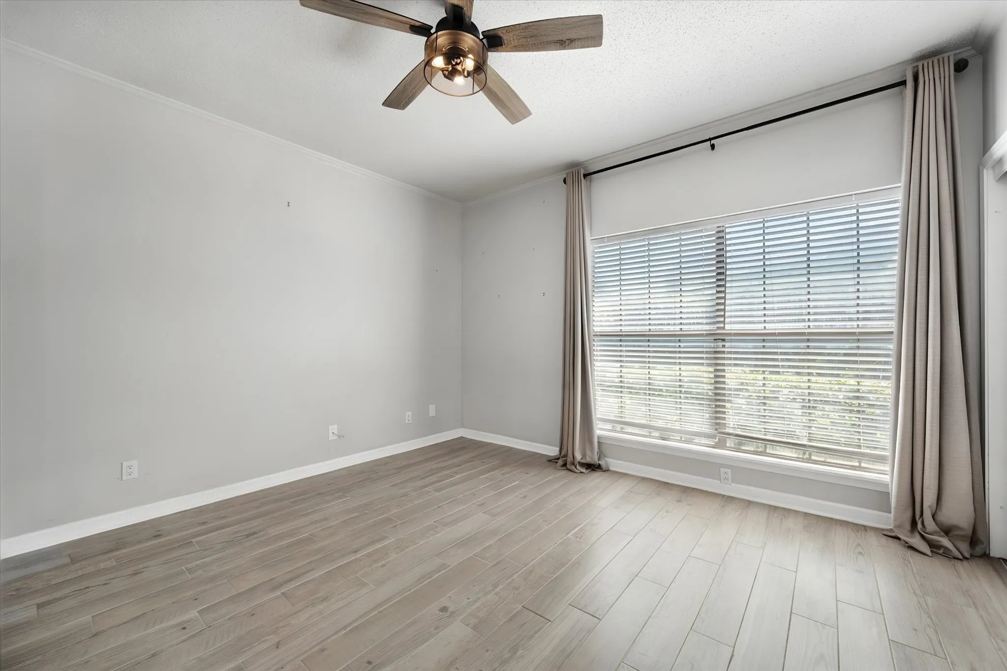 Large bedroom features newer fan, woodlook tile floors, large closet.