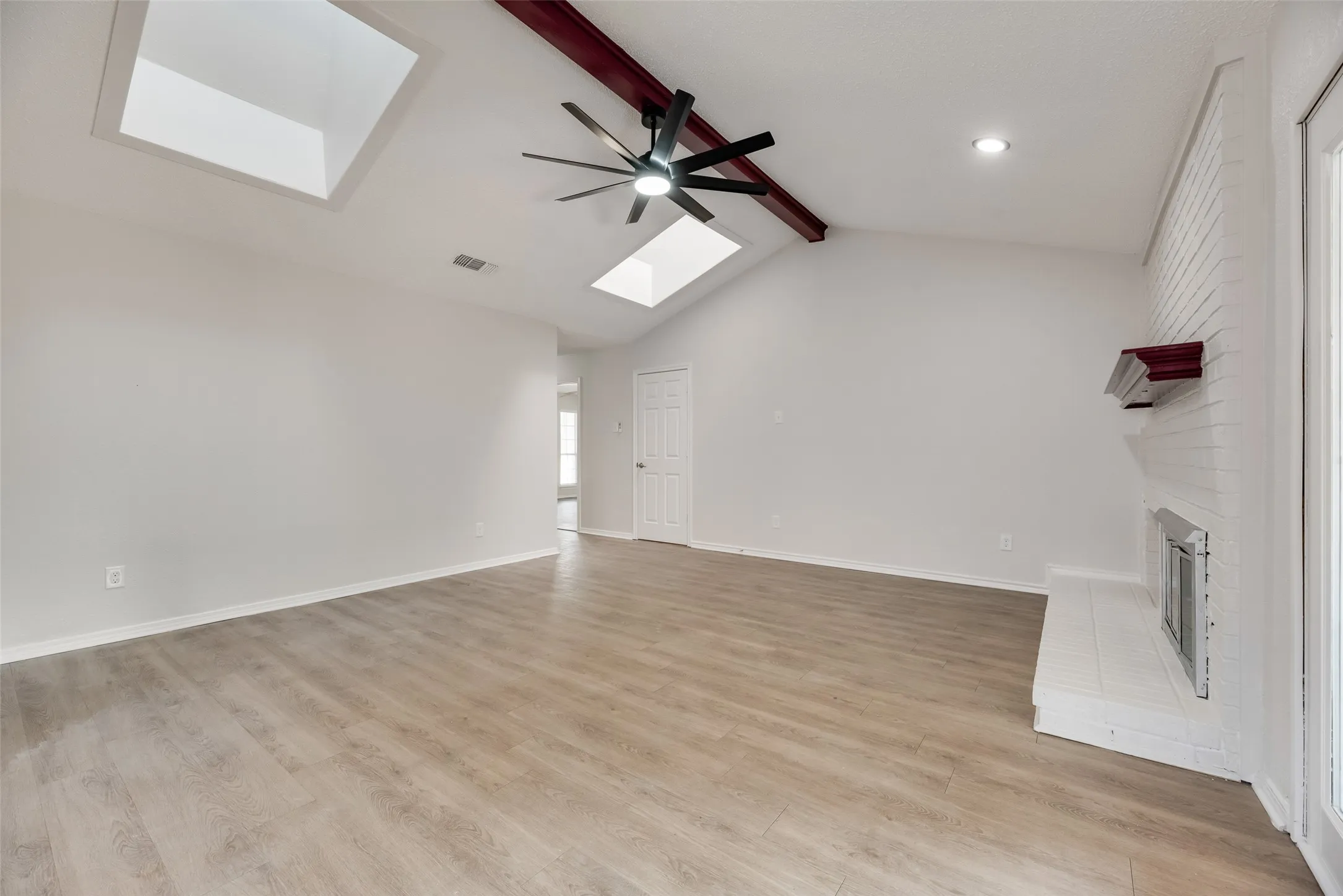 Vaulted ceiling with exposed beam and ceiling fan