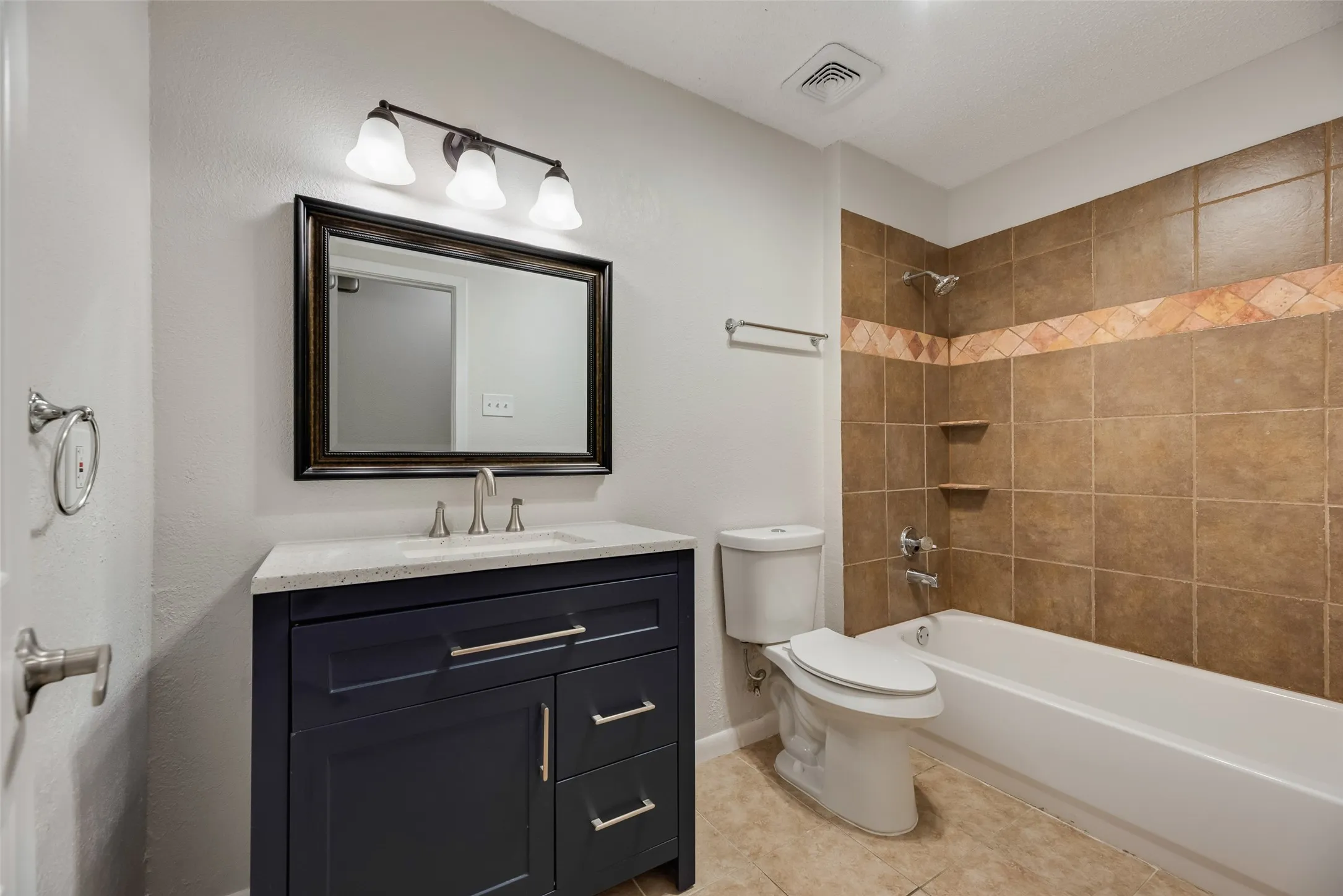 Dark wood-finish vanity with quartz-finish countertop and undermount sink