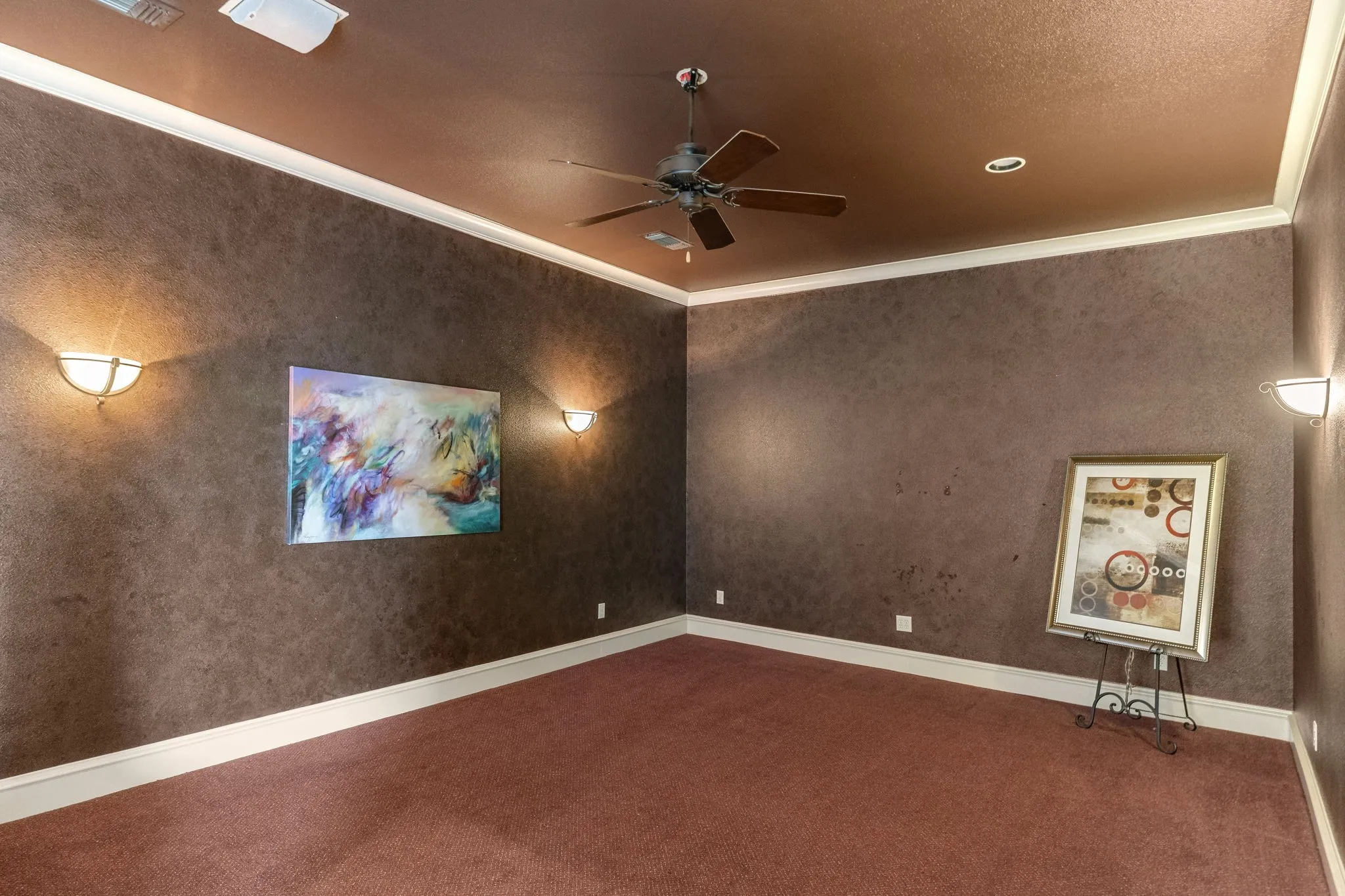 Oversized media room with sconce lighting and crown molding.