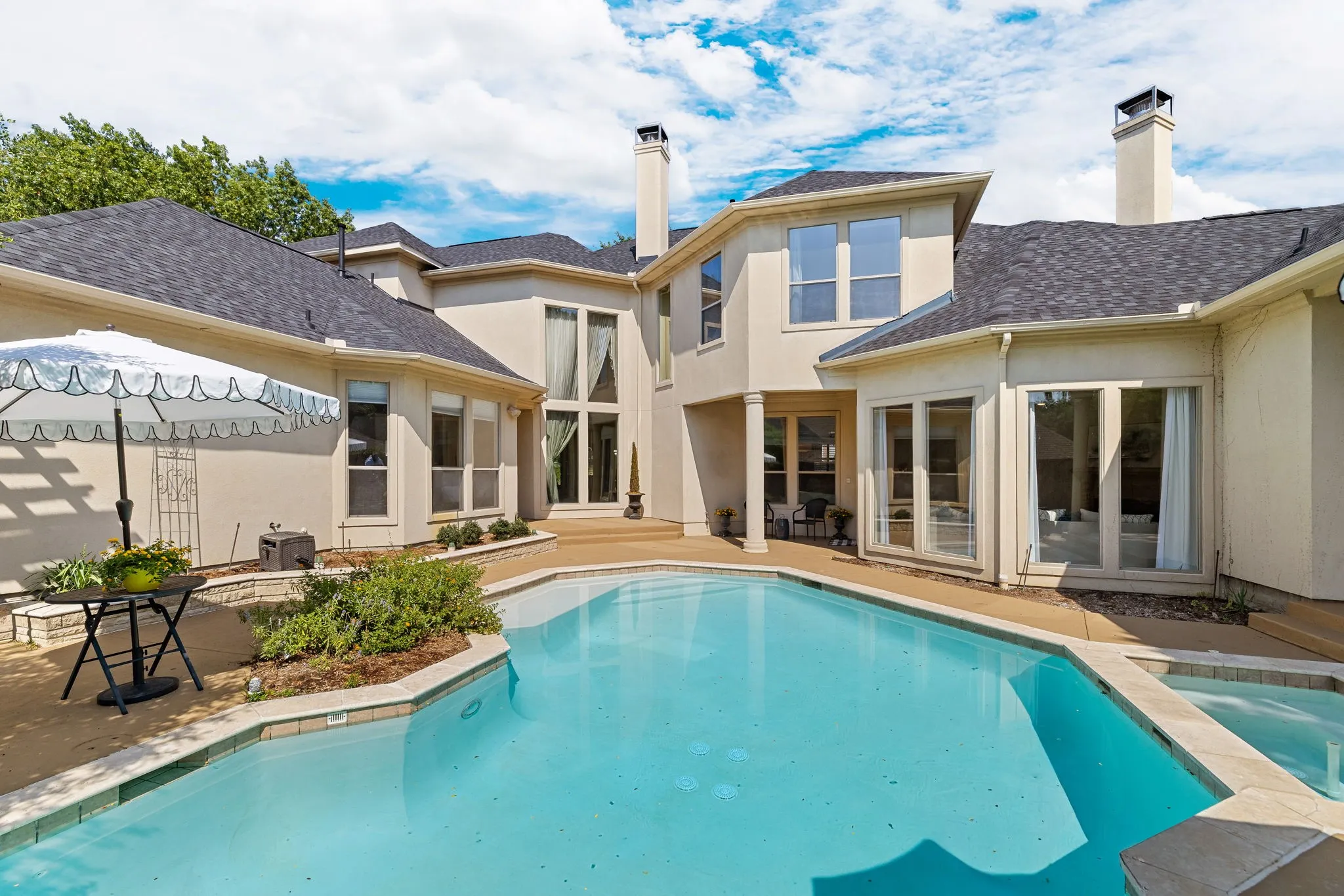 Outdoor oasis showcasing pool, patios, and lounging areas.