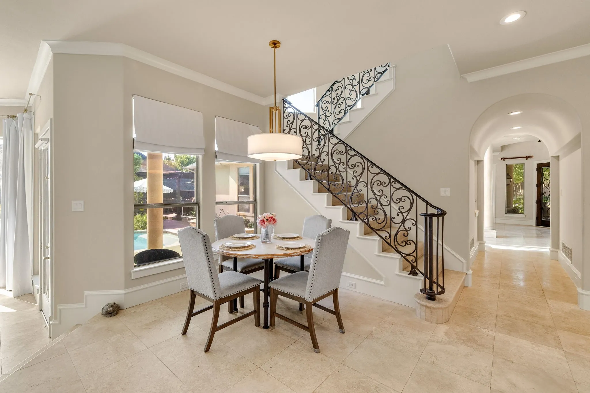 Breakfast room with chandelier and wall of windows with natural light.
