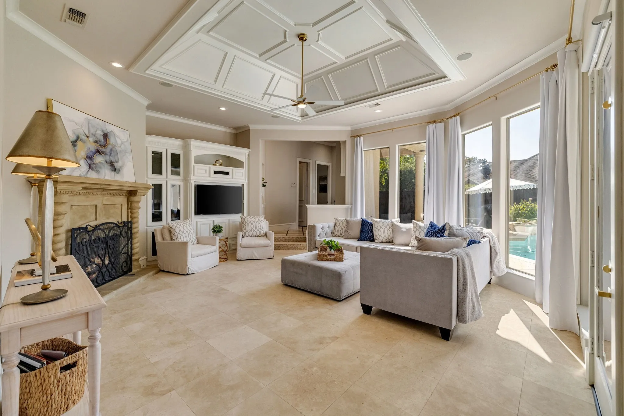 Grand living room with trey ceiling and overlooks the backyard oasis.