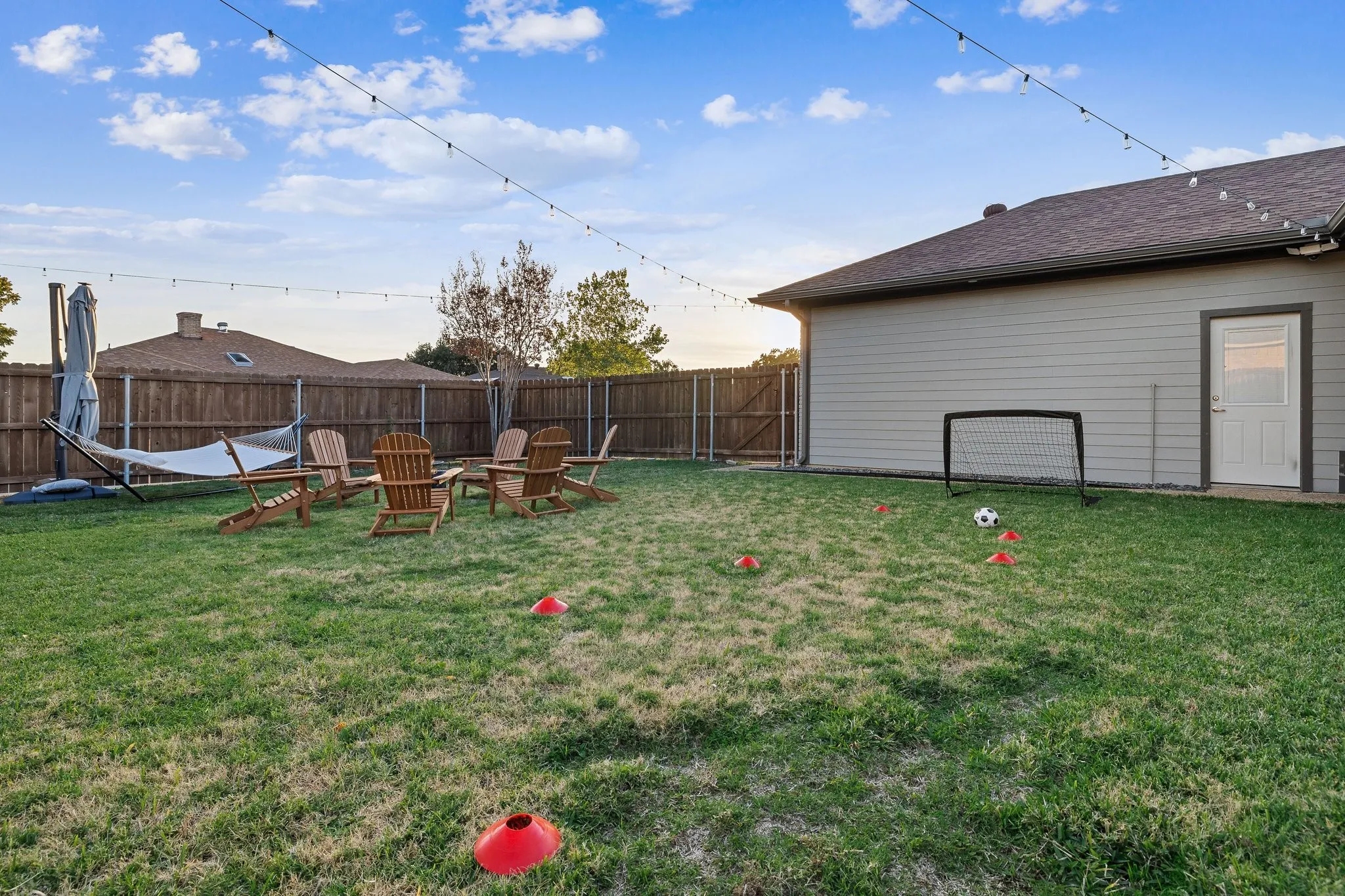 Expansive backyard with level lawn, mature landscaping, and wooden privacy fencing