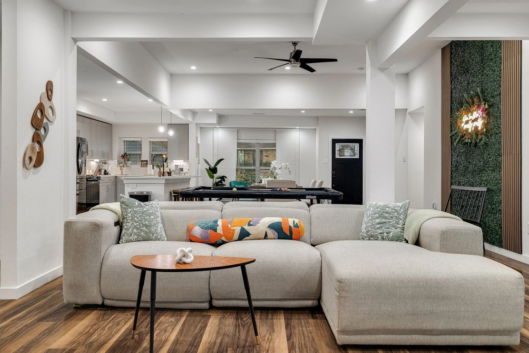 Expansive open-concept living area featuring wood-finish flooring, recessed lighting, and a modern ceiling fan