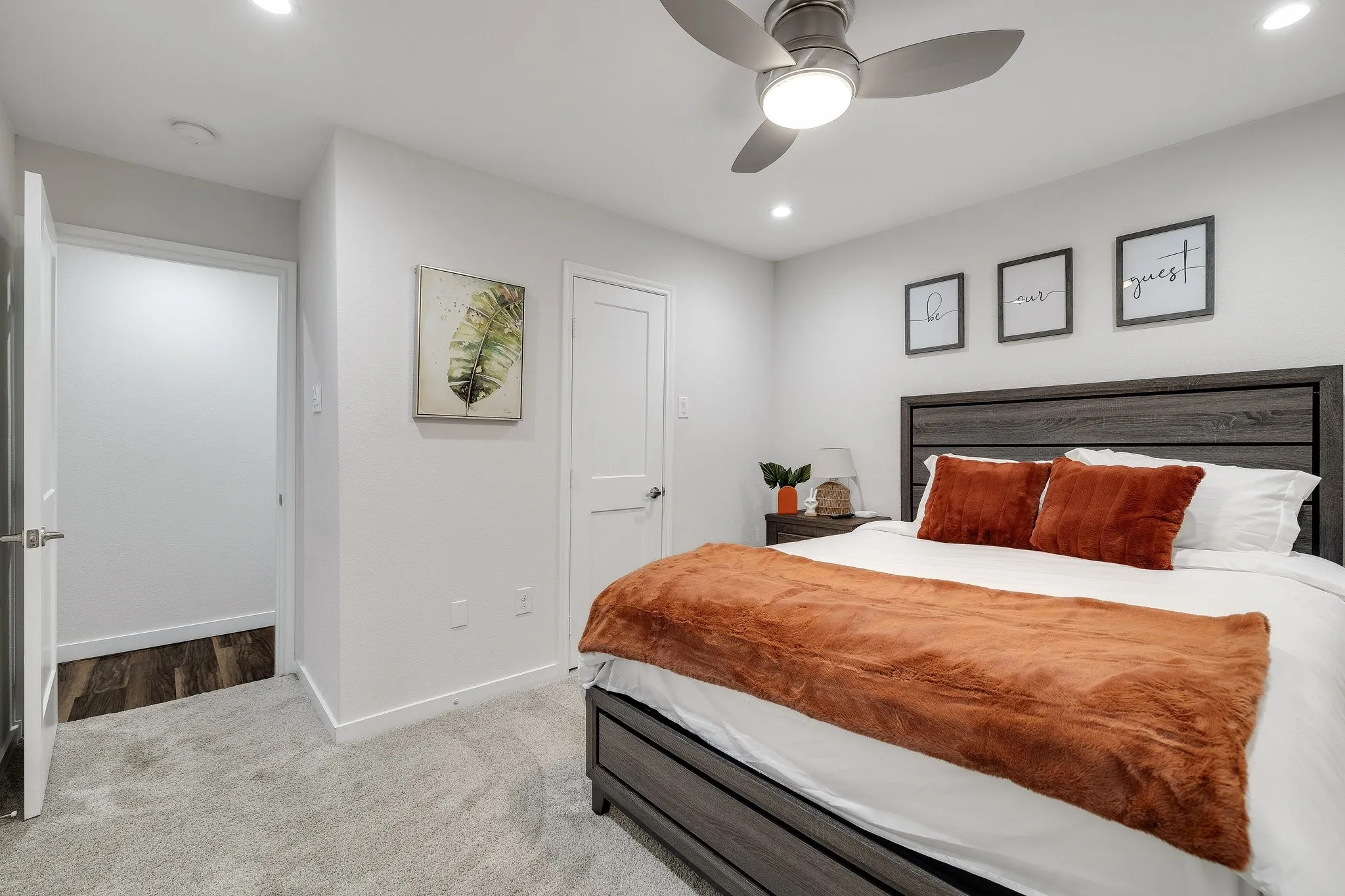 ceiling fan with integrated lighting, neutral carpeting, and soft white wall finishes