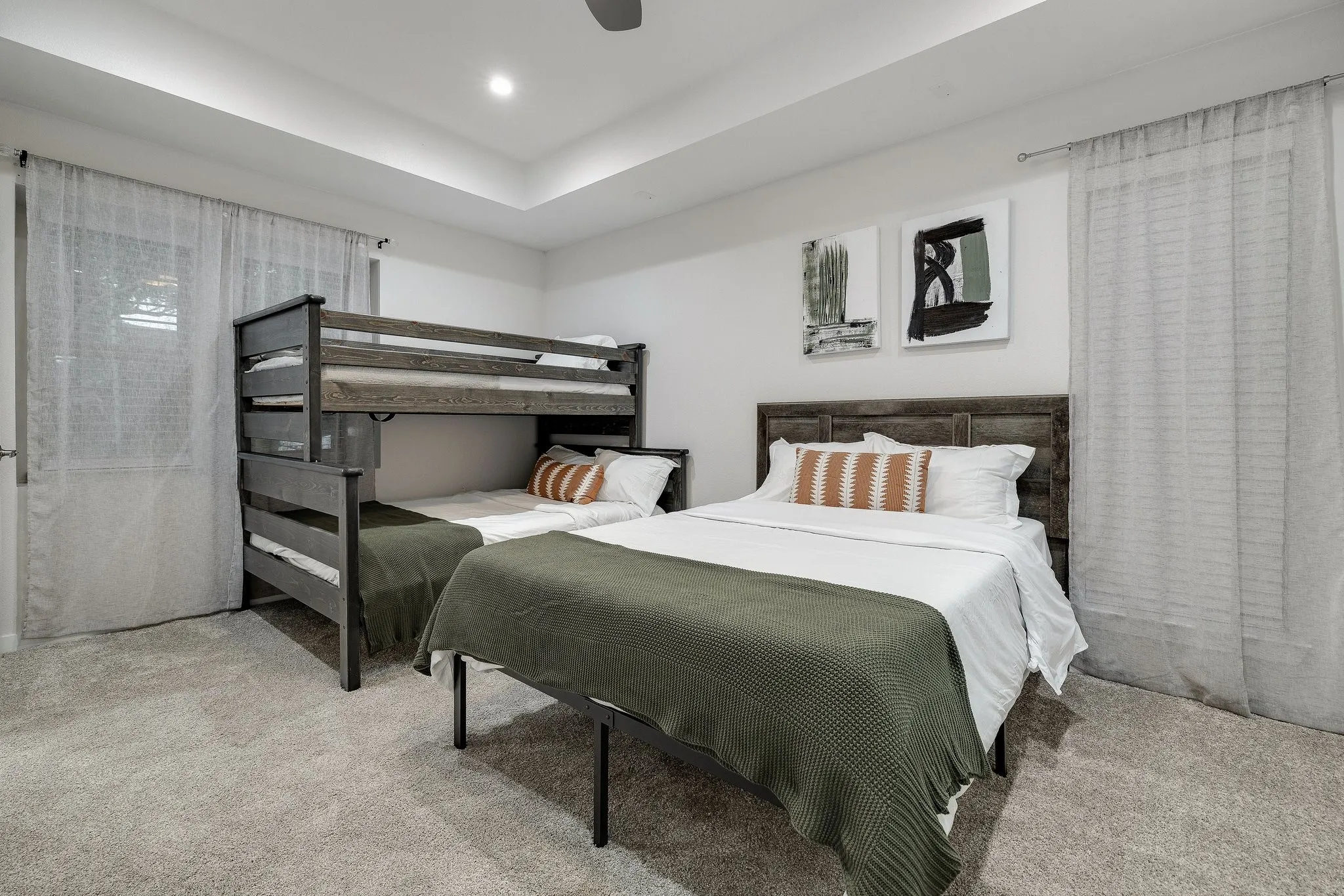 Recessed ceiling lighting, tray ceiling, wall-to-wall carpeting, window with sheer curtains