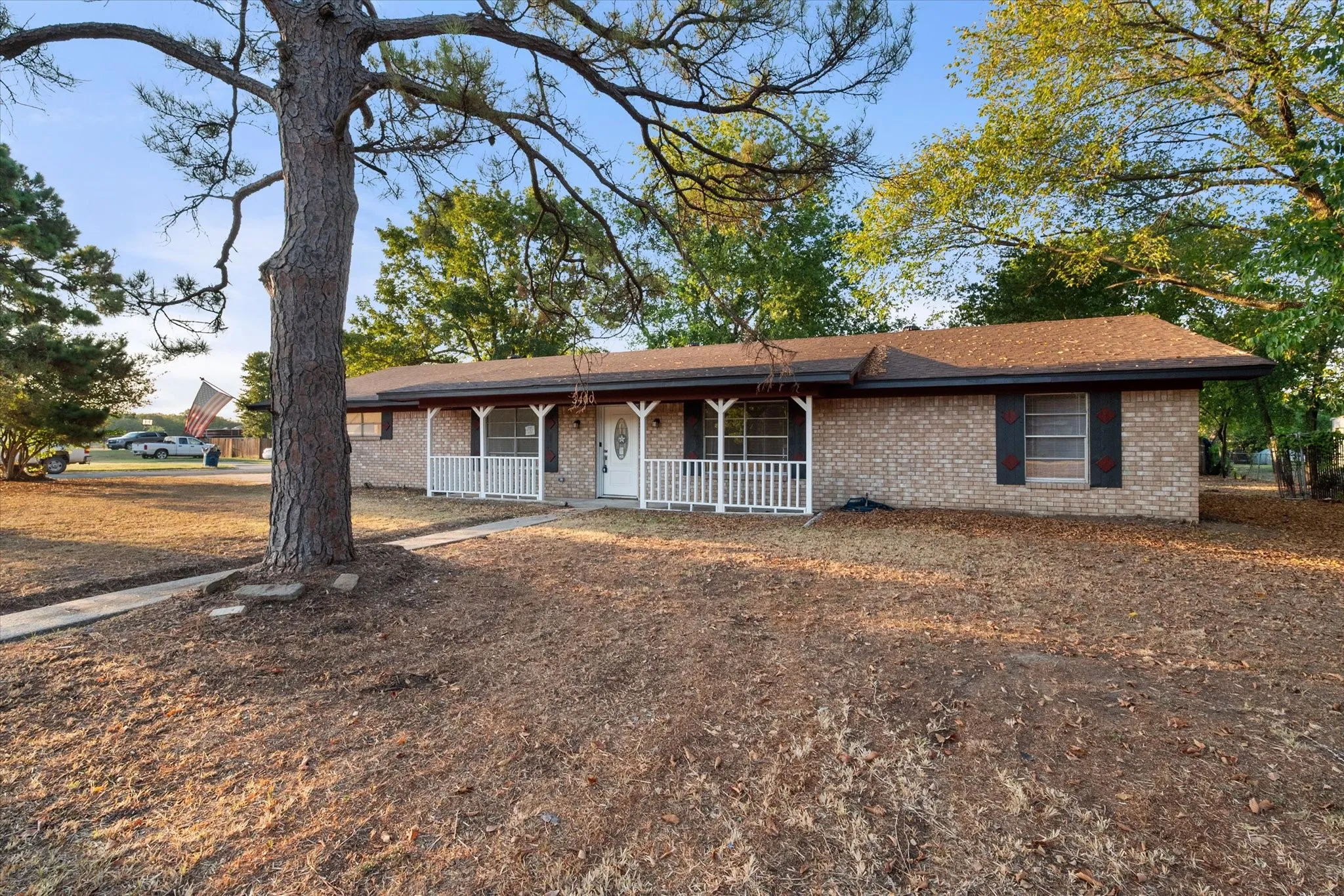 Brick exterior with white front porch railing and dark shutters