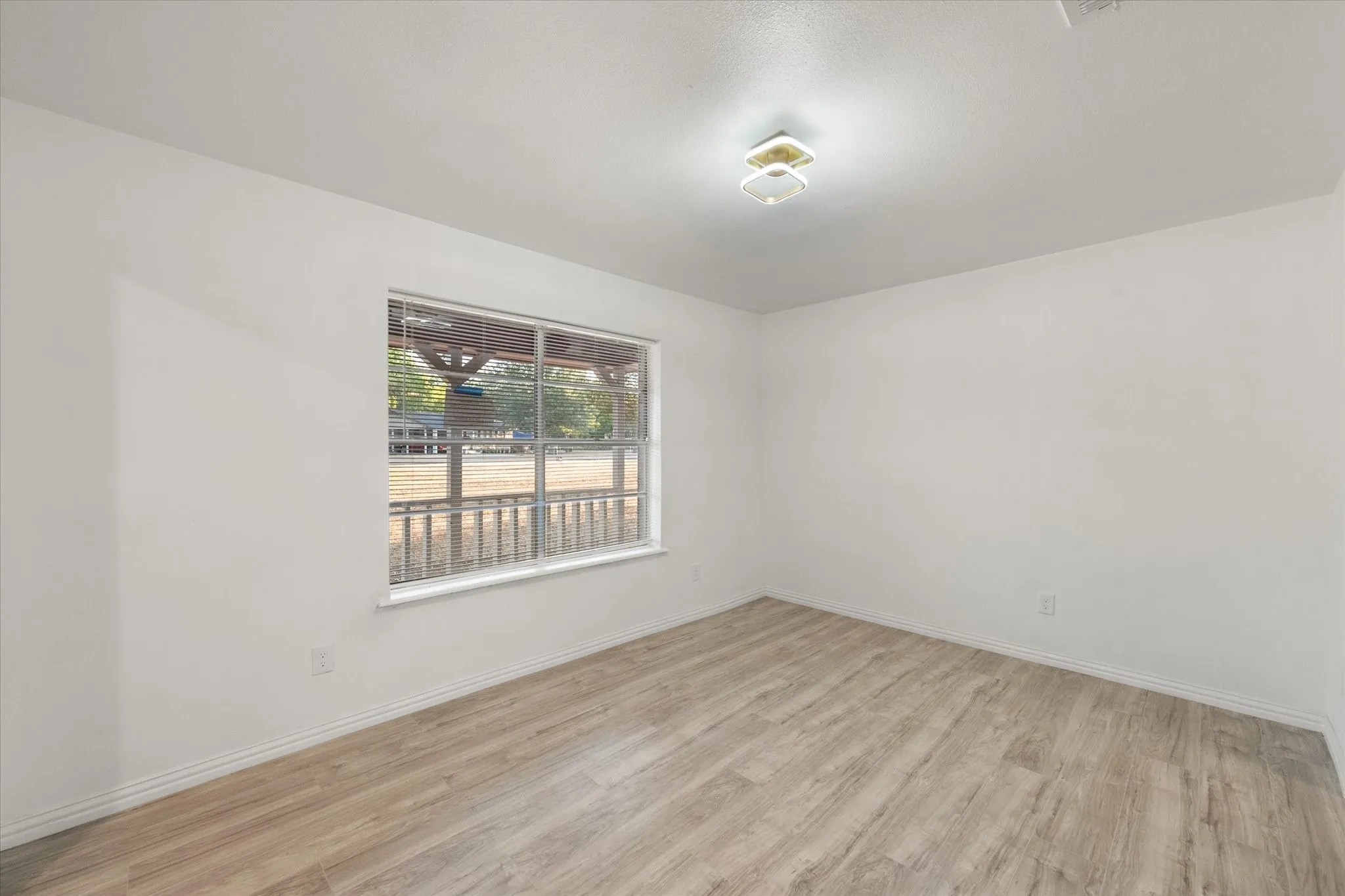 Recessed lighting, wood-finish flooring, and white walls