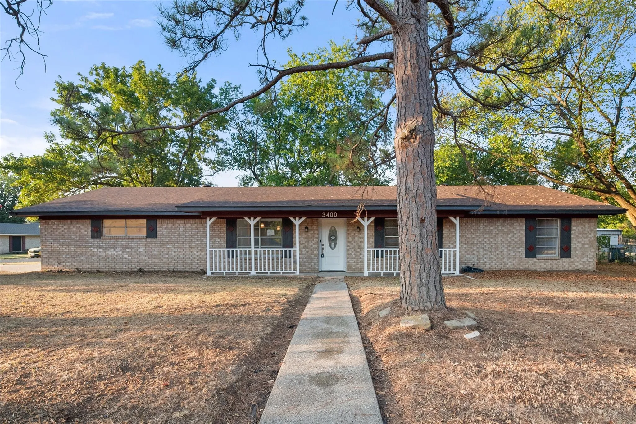 Brick exterior with a covered front porch featuring white railings