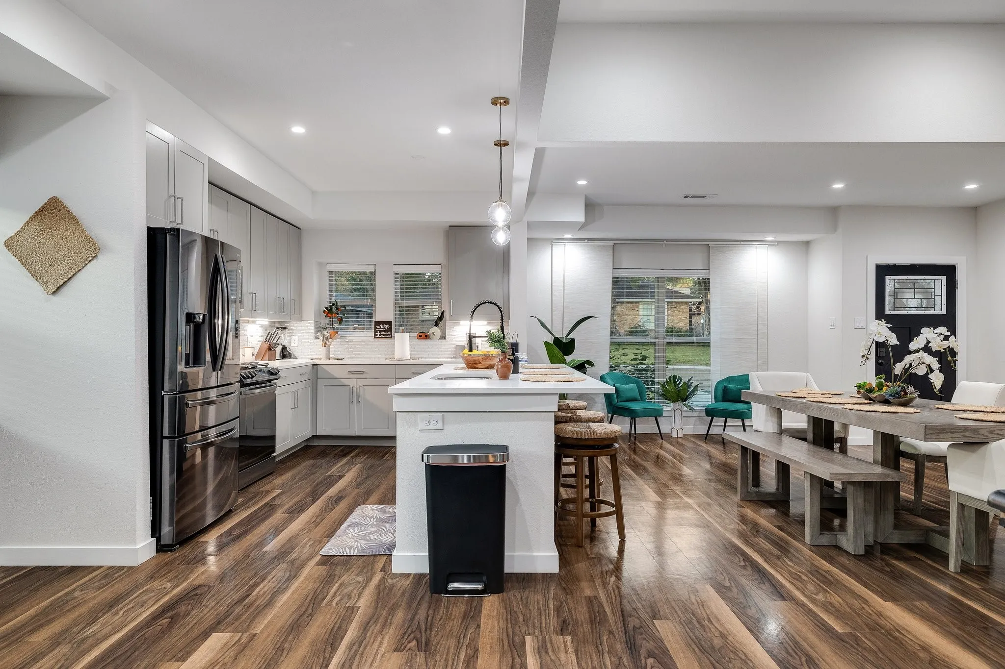 Spacious kitchen with a central island, stainless steel appliances, and light cabinetry