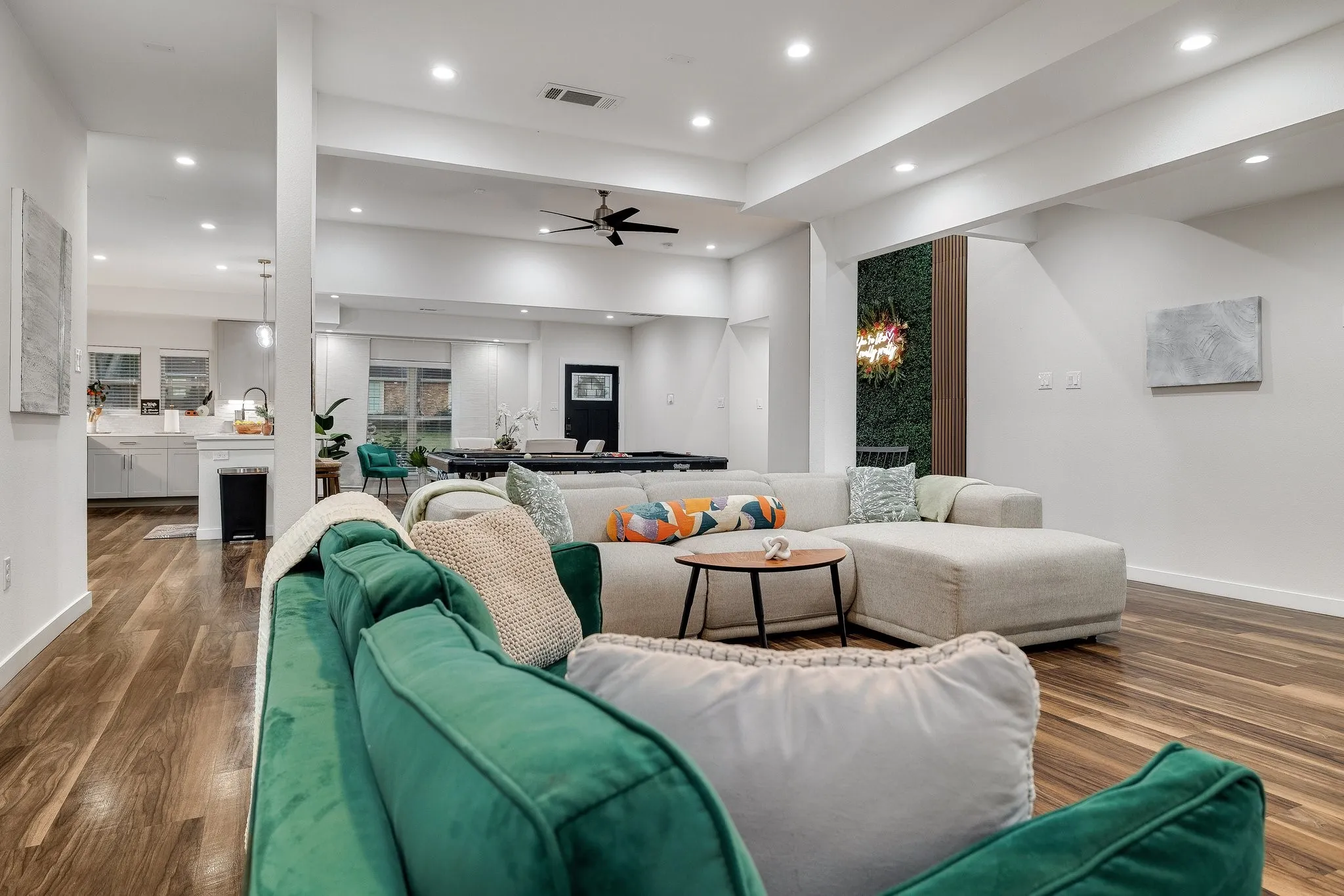 Open-concept living area featuring wood-finish flooring throughout, recessed ceiling lighting, and a ceiling fan