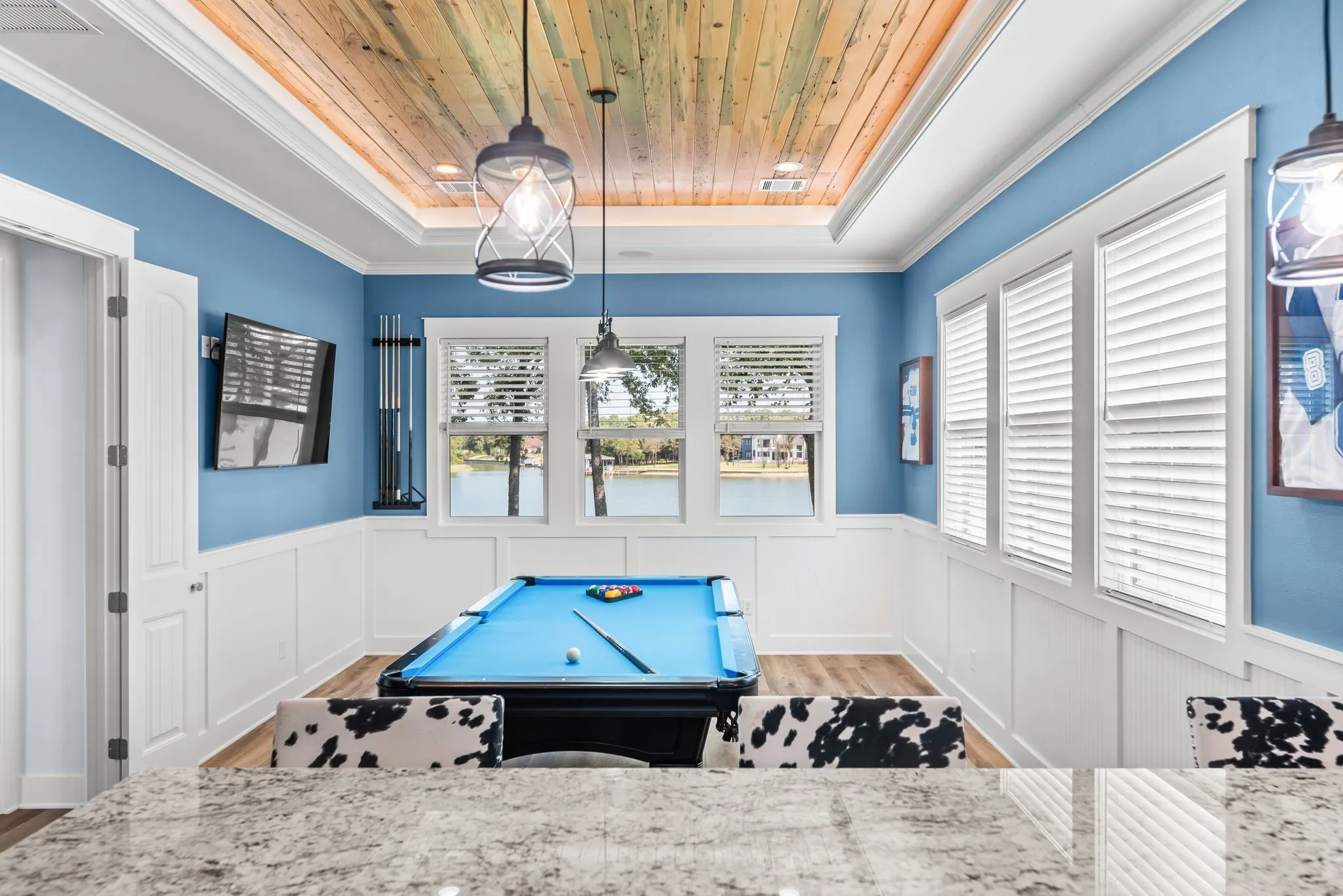 Spacious game room offers a fun entertainment retreat with pool table, natural light, custom details, and room for family and guests.