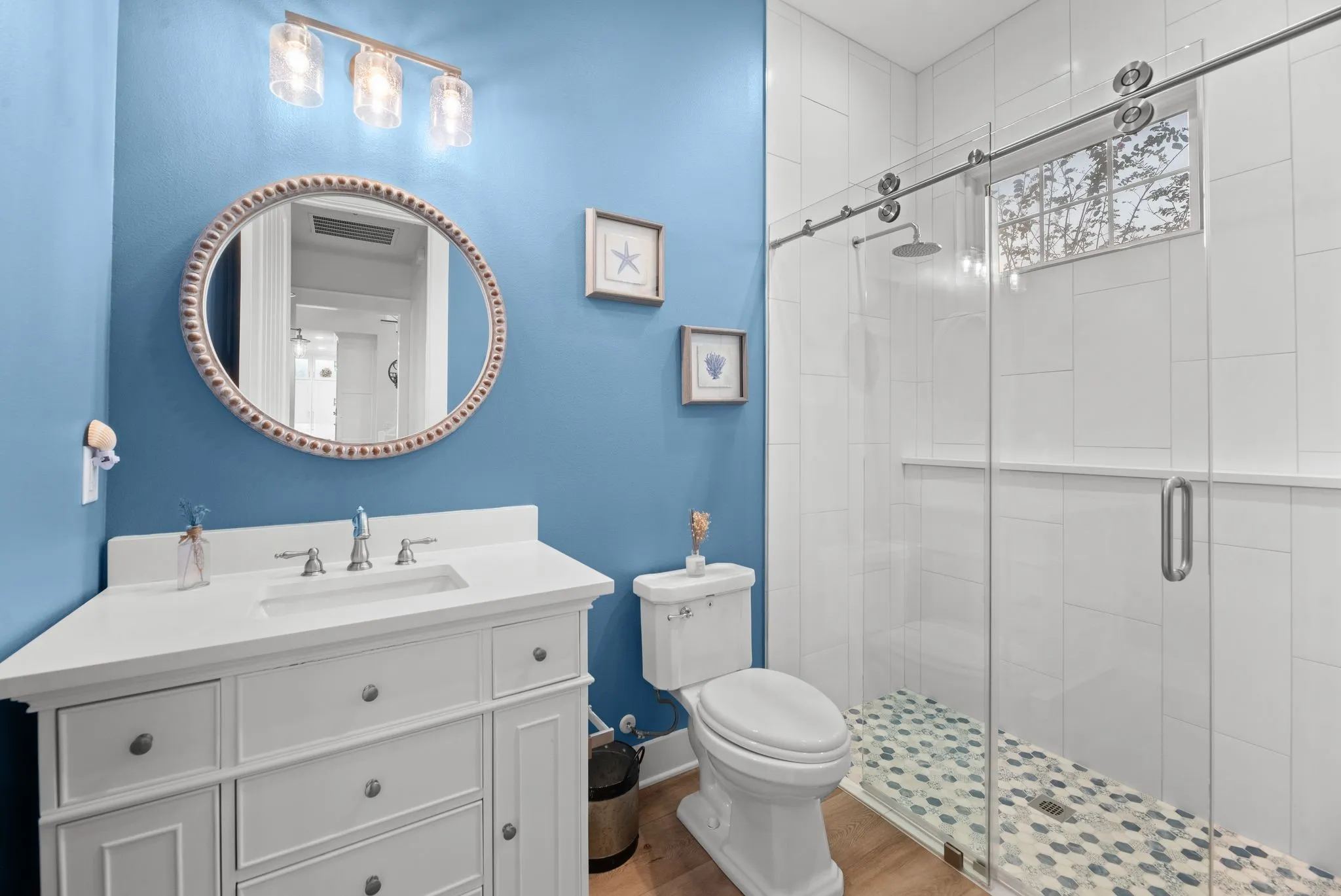 Full guest bathroom features a walk-in shower, modern vanity, and fresh blue-and-white finishes.