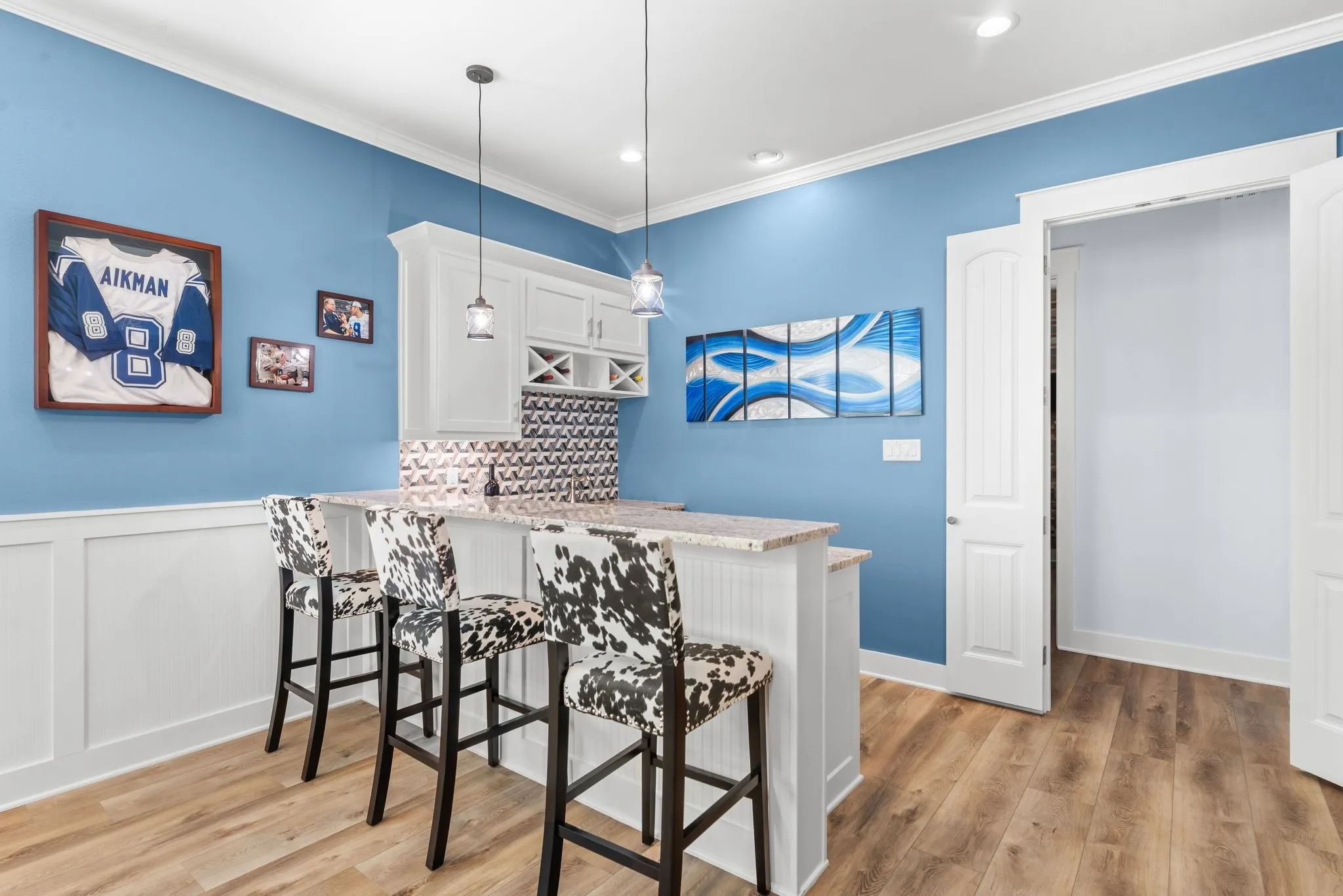 Full wet bar with seating, custom cabinetry, and stylish blue finishes makes this game room ideal for entertaining at the lake.