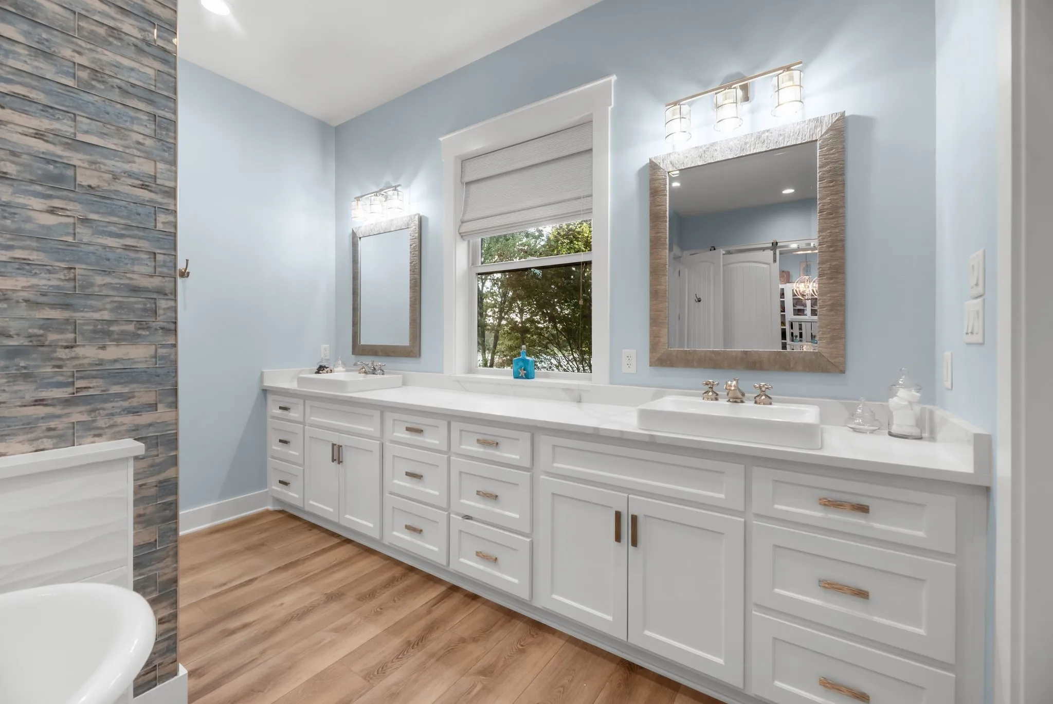 Dual vanity provides abundant cabinetry, generous counter space, and elegant finishes in the spacious primary bathroom.