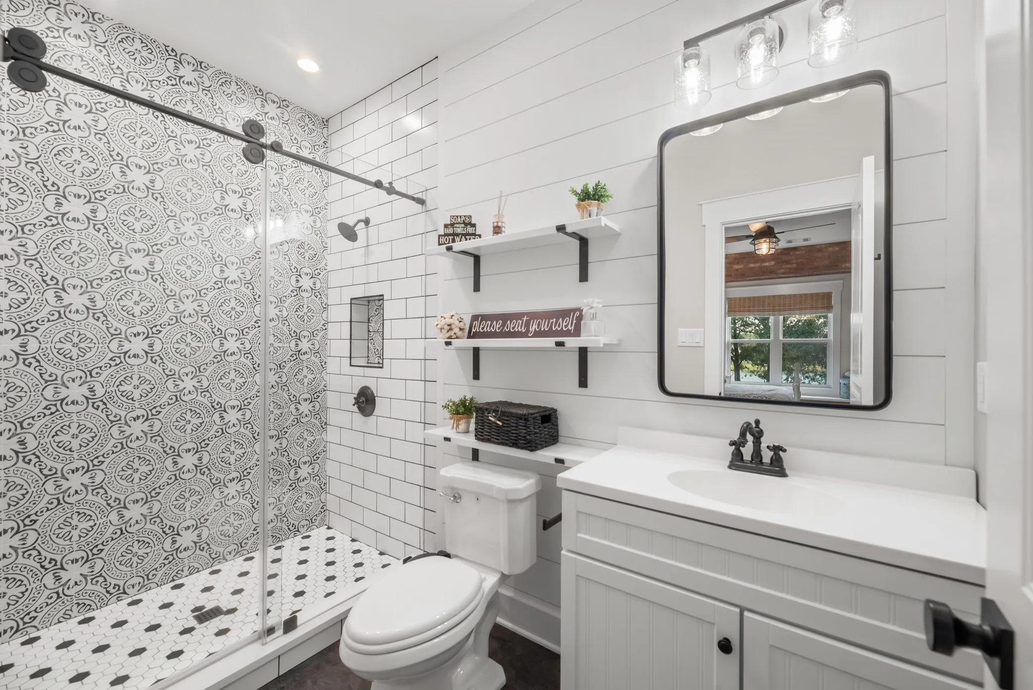 Beautiful tiled guest bath features a spacious shower, contemporary vanity, and coordinated finishes for a polished modern look.