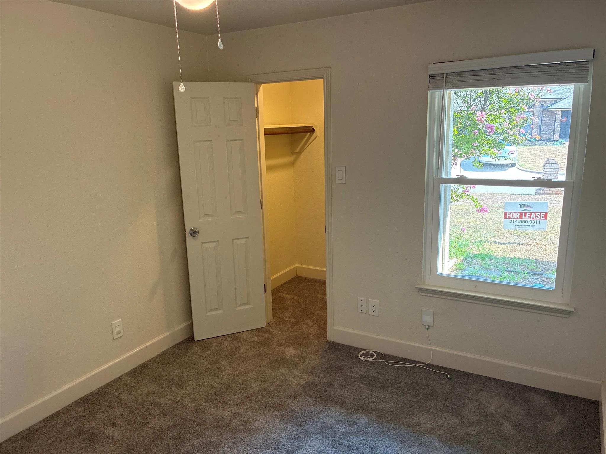 Carpeted room featuring a ceiling fan, a window with blinds, and a closet with a built-in shelf