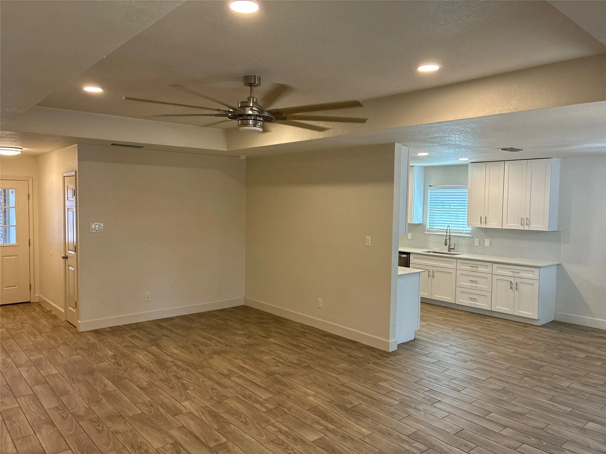 Wood-finish flooring throughout, recessed lighting, and a modern ceiling fan