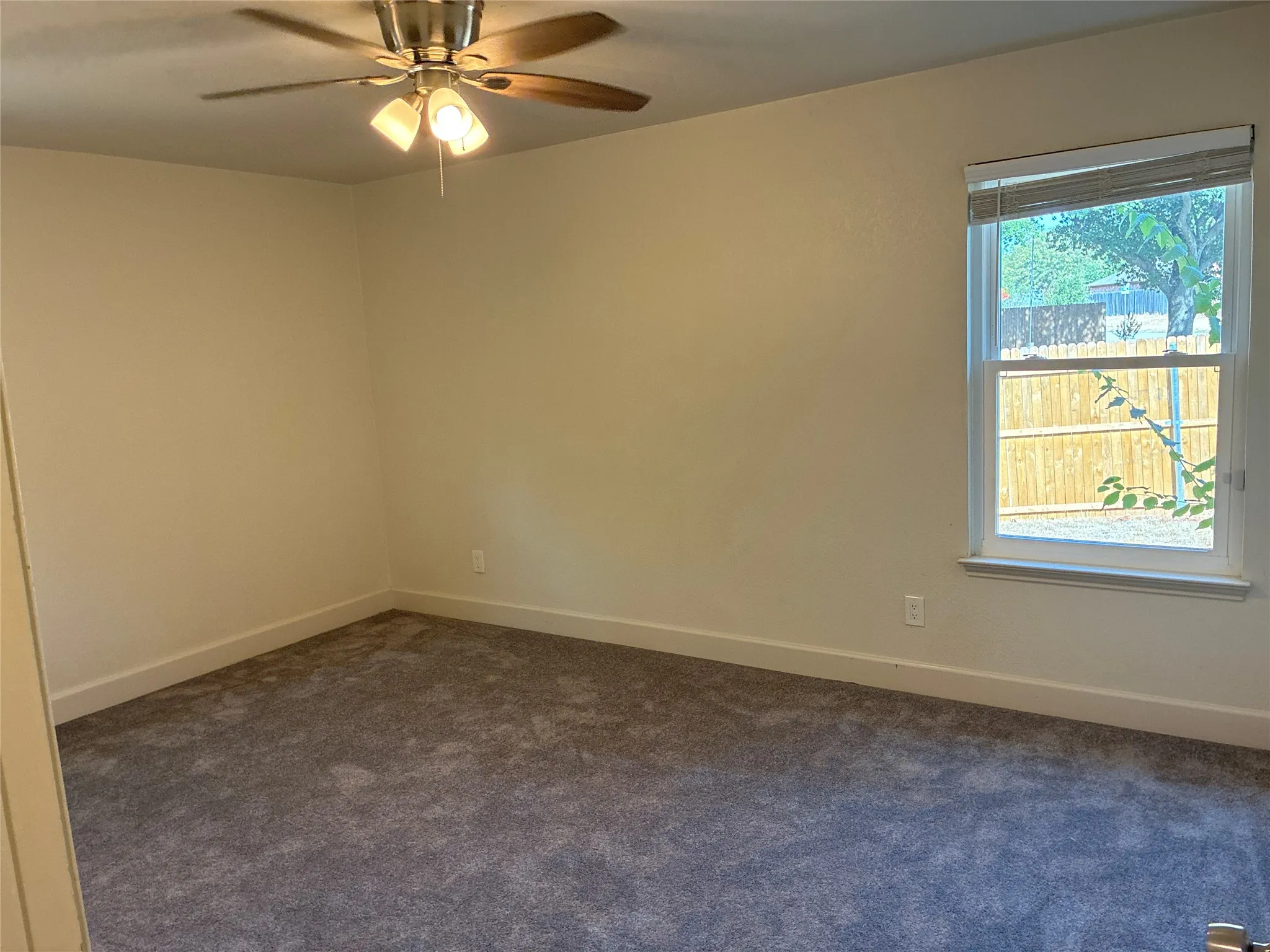 Window with blinds, wall-to-wall carpeting, and a ceiling fan with integrated lighting