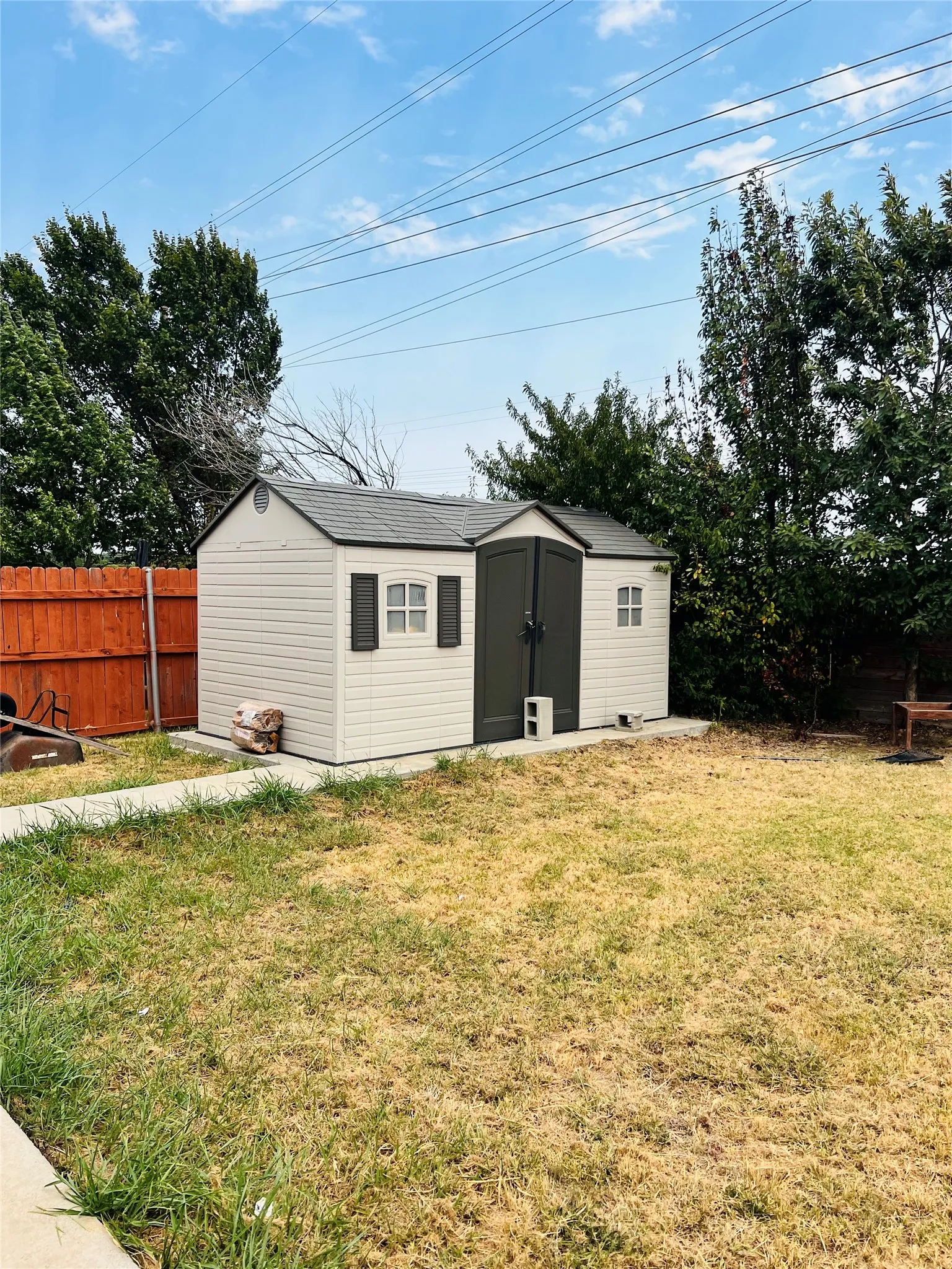 Outdoor storage shed with dual-door entry and decorative window shutters