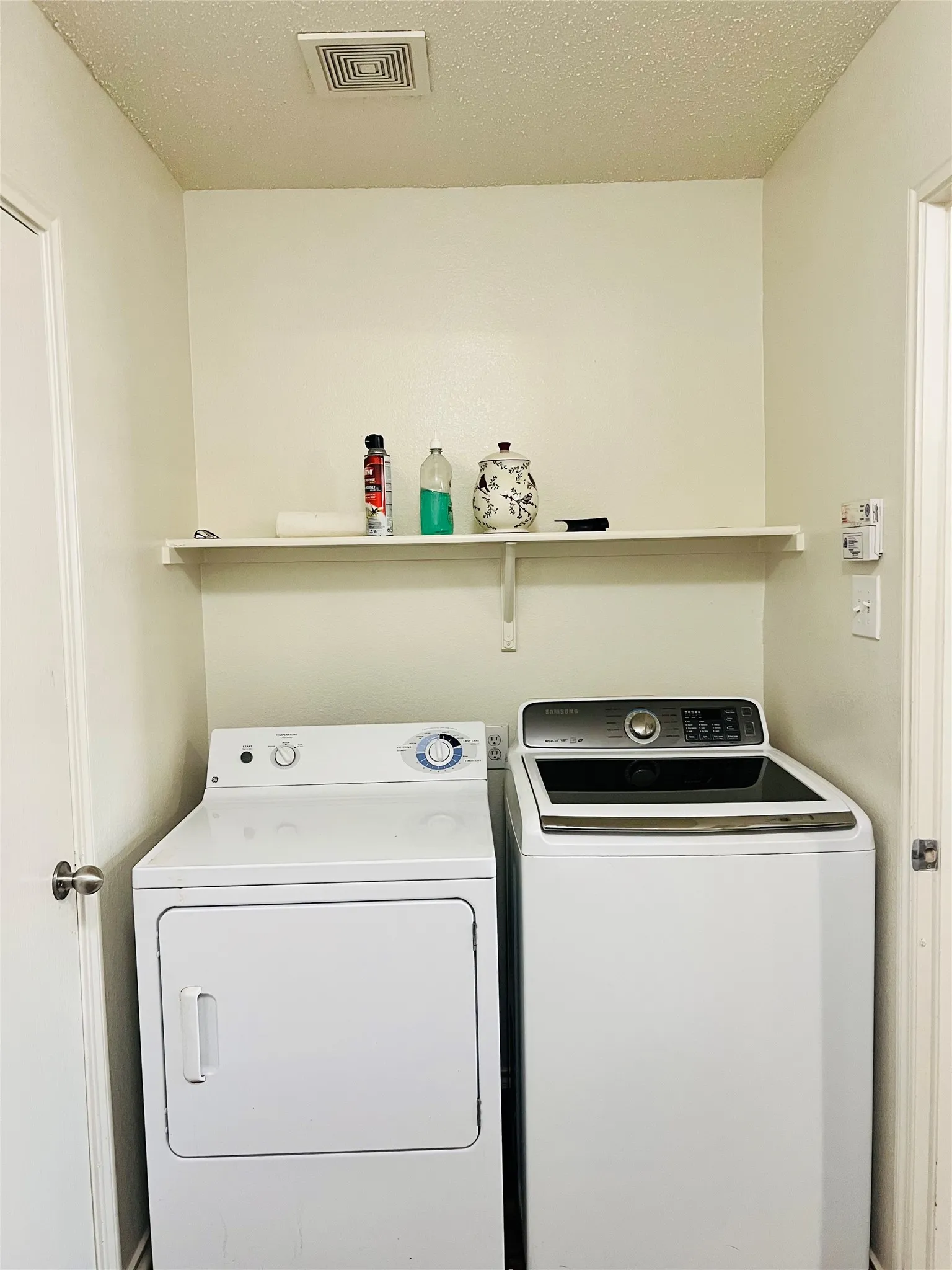 Laundry area with overhead shelving