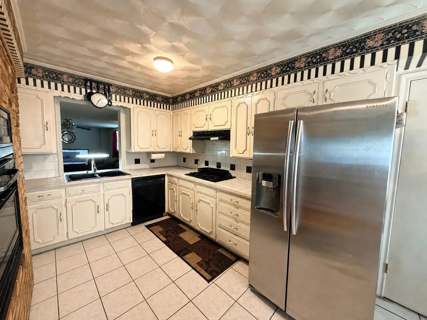 Kitchen featuring light-toned cabinetry, tile flooring, and a stainless steel side-by-side refrigerator