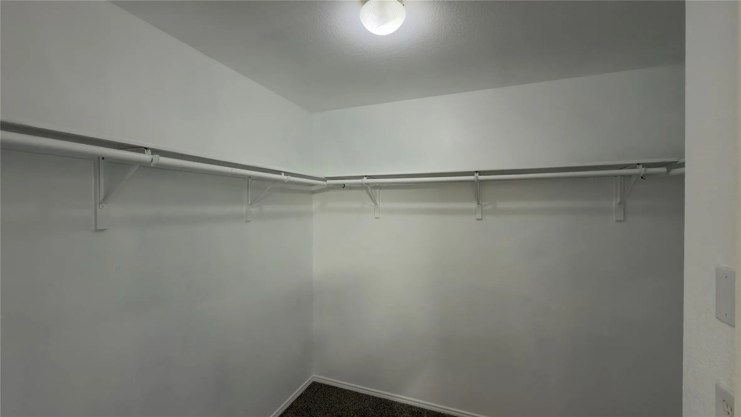 Walk-in closet with white walls and built-in shelving