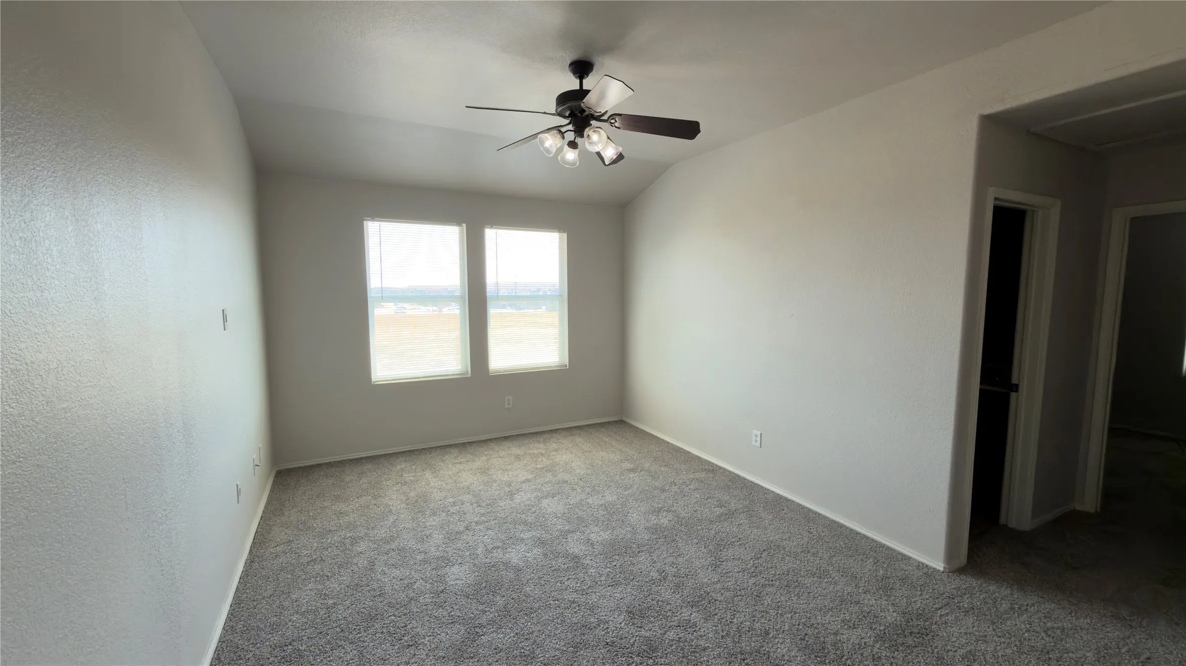 Carpeted room with a ceiling fan, two windows, and neutral-toned​​‌​​​​‌​​‌‌​‌‌​​​‌‌​‌​‌​‌​​​‌​​ walls