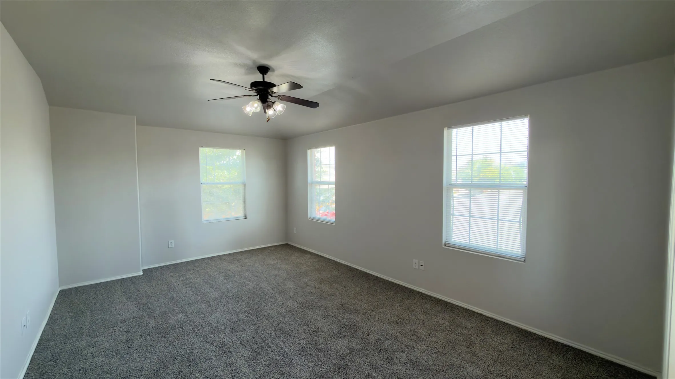 Carpeted flooring, ceiling fan with integrated lighting, multiple windows with blinds, neutral wall paint