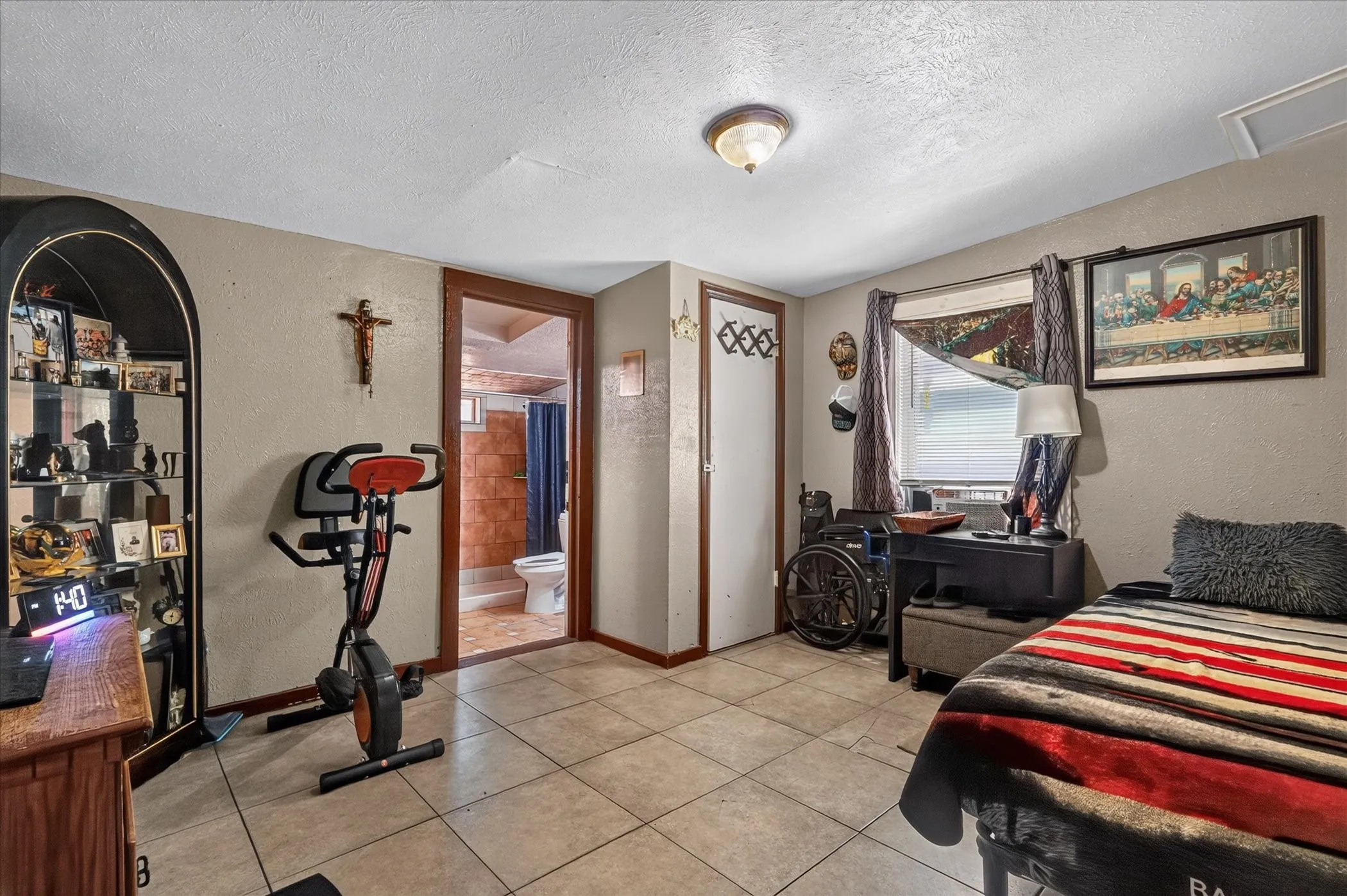 Tile flooring, neutral wall tones, window with natural light, recessed lighting, and an adjacent bathroom