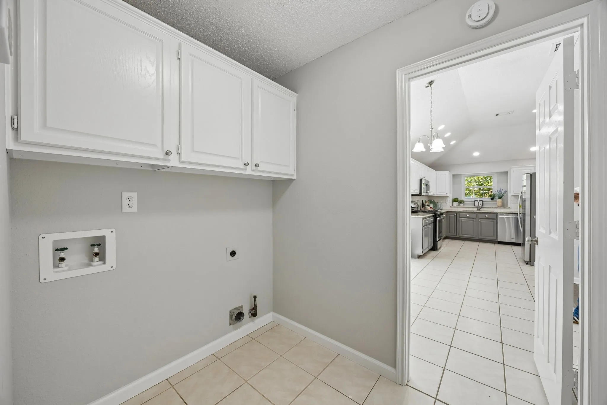 Check out this spacious laundry room - lots of cabinet space, too and conveniently located!