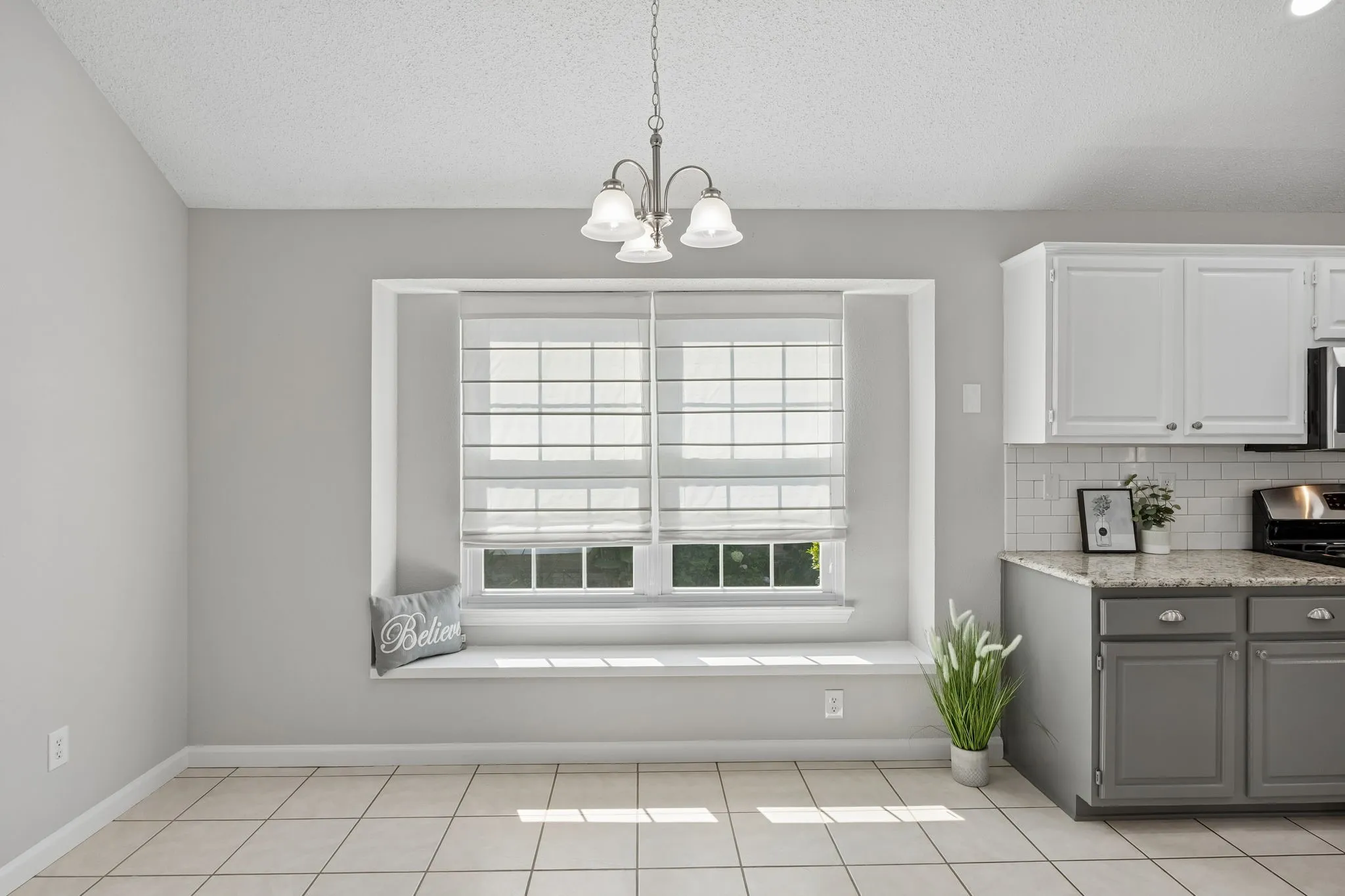 The breakfast area is filled with natural light and features updated lighting and a charming window seat—perfect for morning coffee