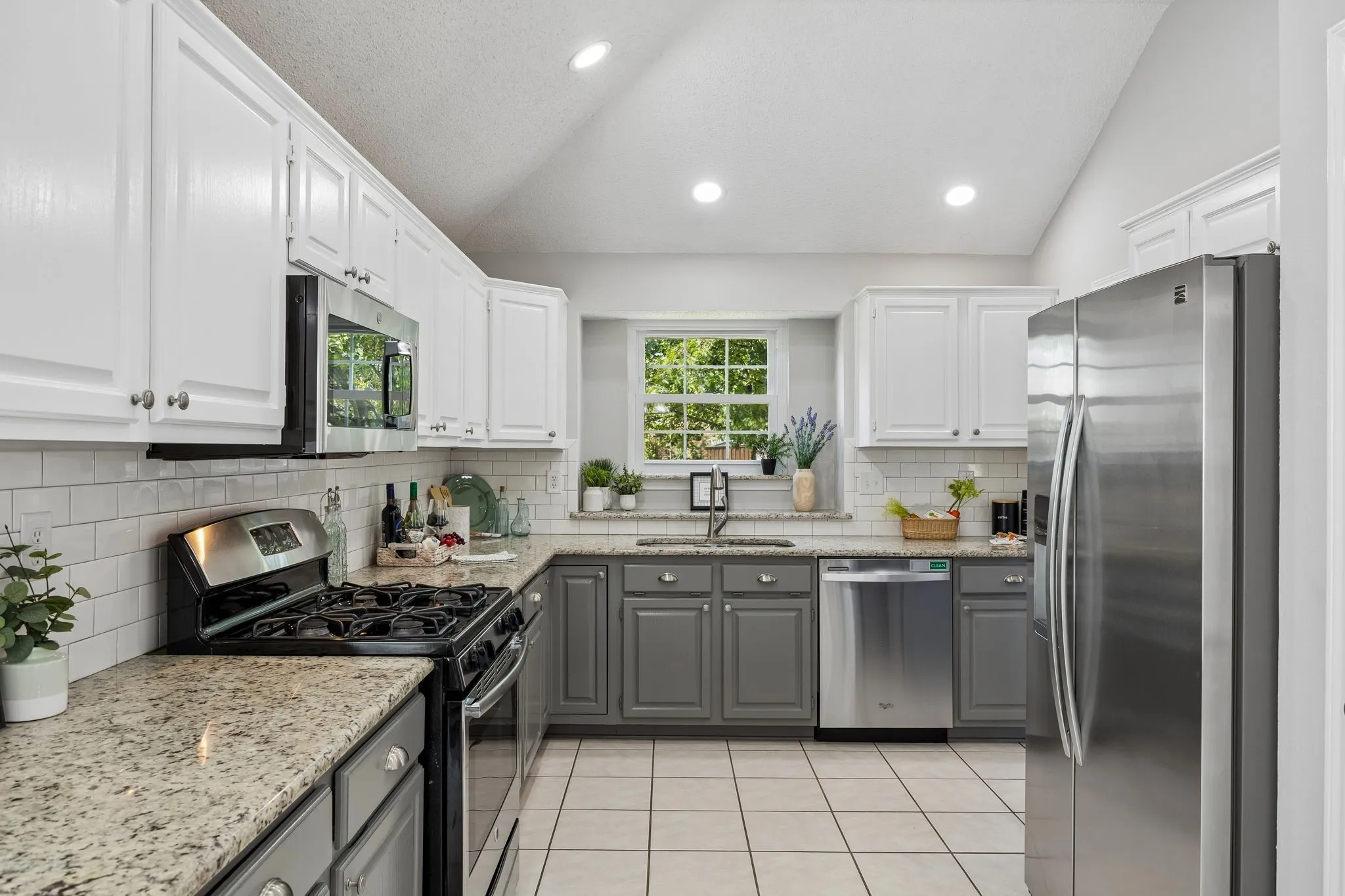 The gourmet kitchen shines with granite countertops, freshly painted cabinetry, undermount sink, SS appliances, new microwave, and a sought-after gas range. A delightful plant ledge above the sink adds character and overlooks the front of the home.