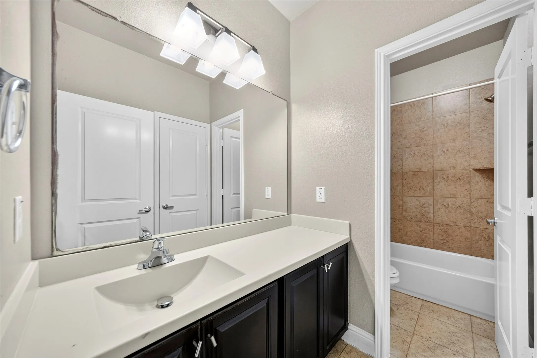 Vanity with an integrated sink, polished chrome faucet, and dark wood-finish cabinetry