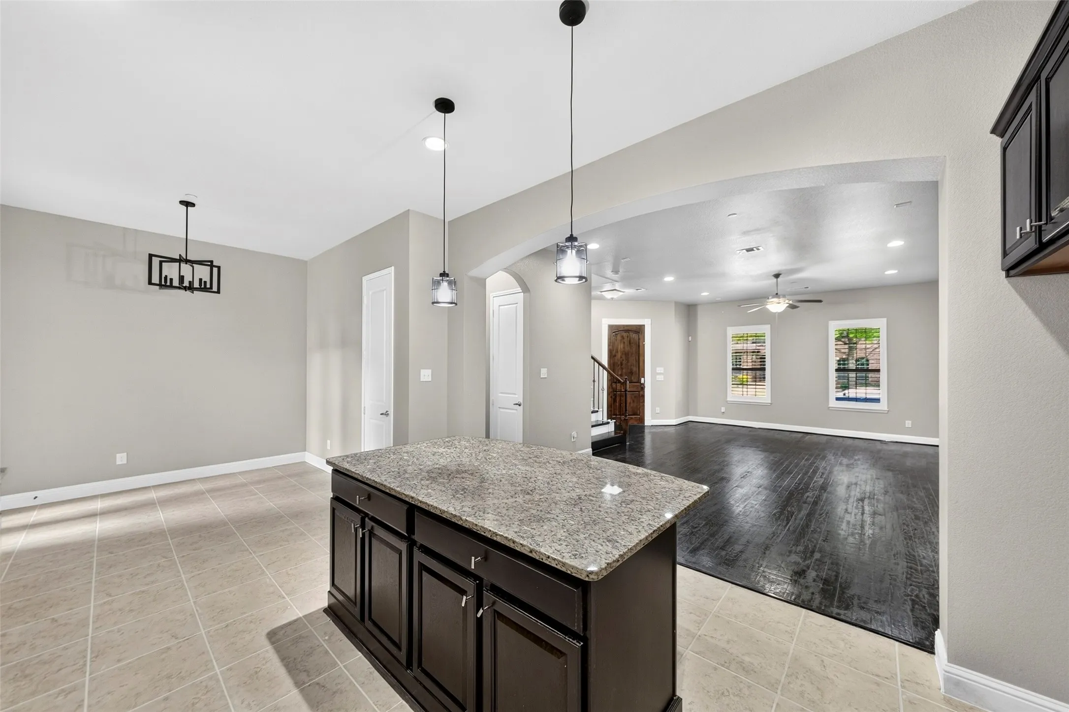 Kitchen island with granite countertop and dark wood cabinetry