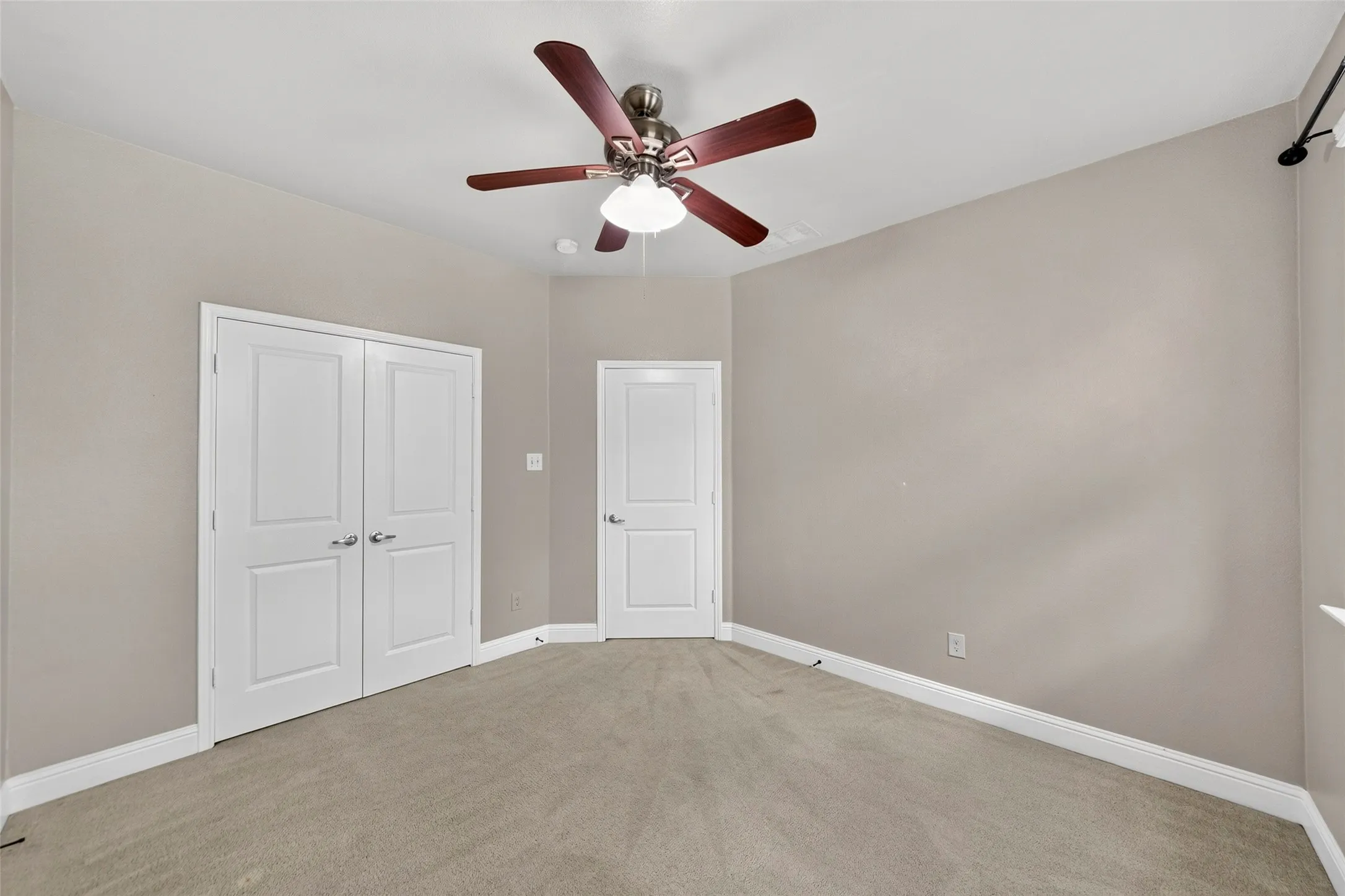 Neutral wall finishes, recessed lighting, and a ceiling fan with integrated lighting