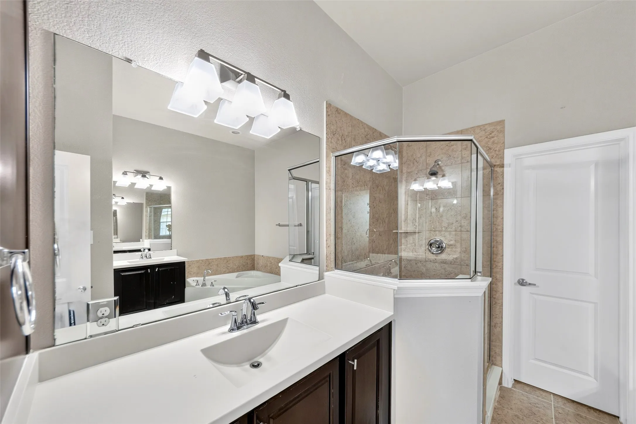Dual vanity with white countertops, dark wood-finish cabinetry, and undermount sinks